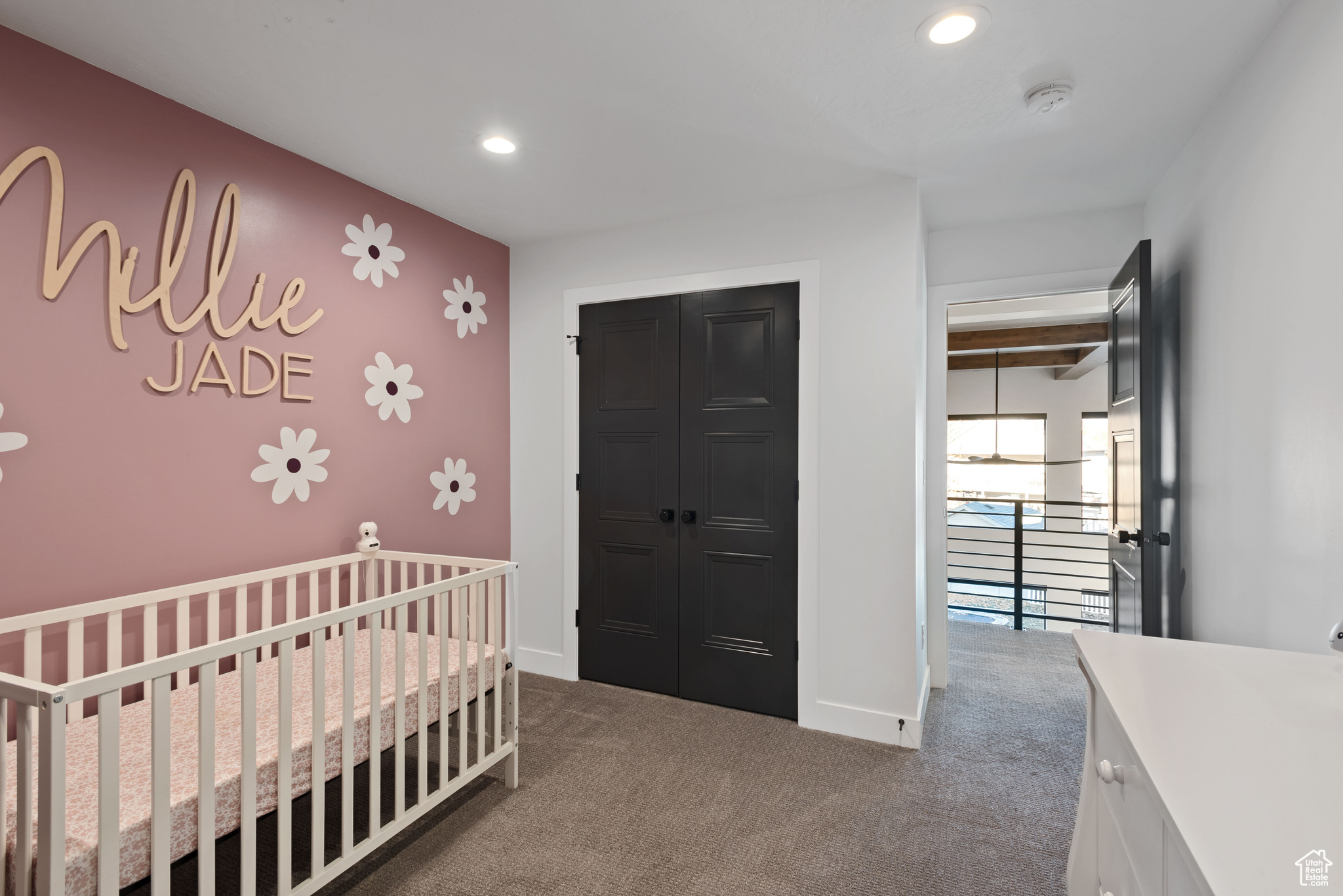 Carpeted bedroom with a closet and a nursery area