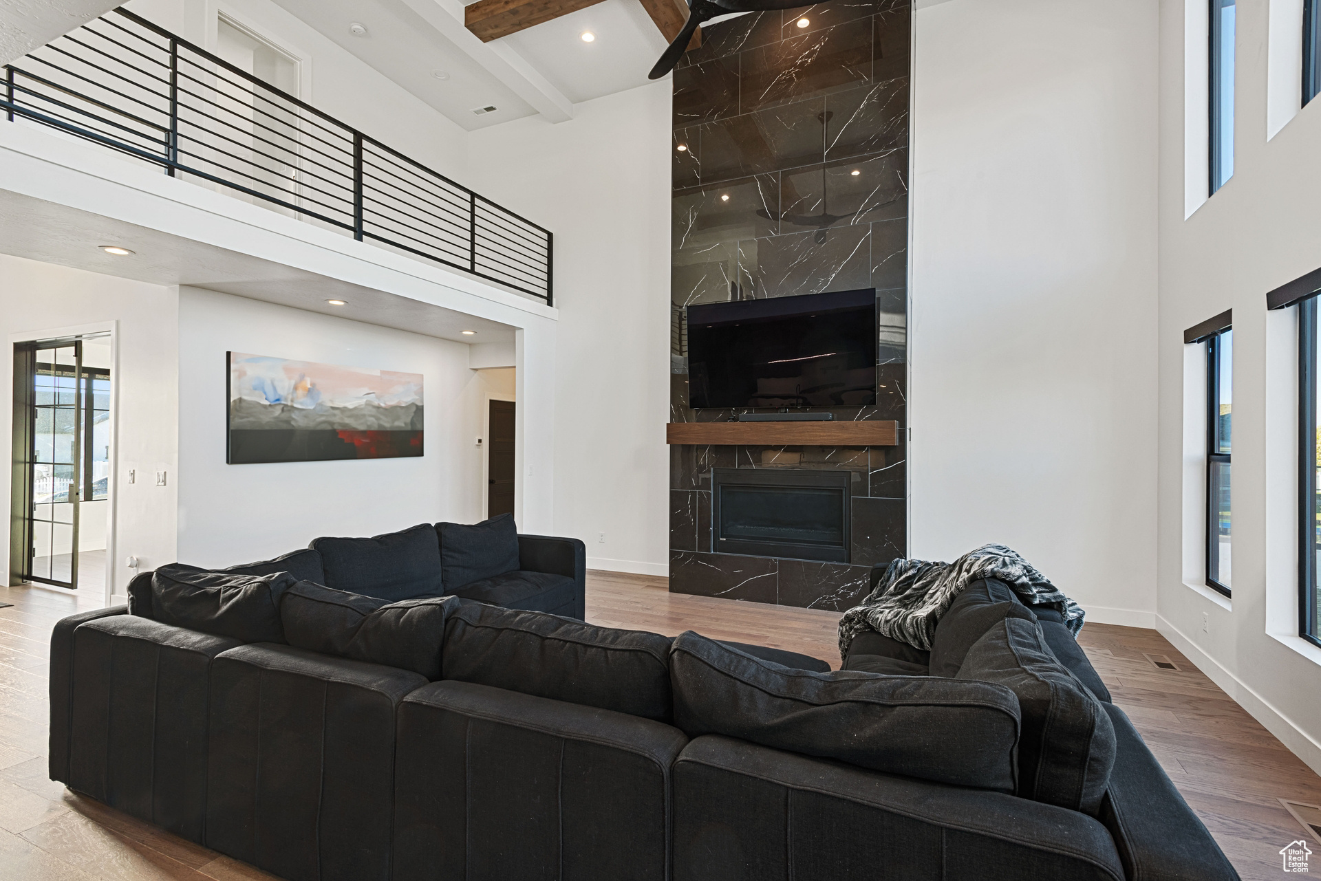 Living room with a high ceiling, a wealth of natural light, and hardwood / wood-style floors