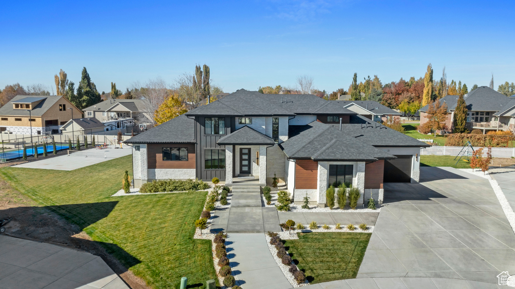 View of front of property with a garage and a front lawn