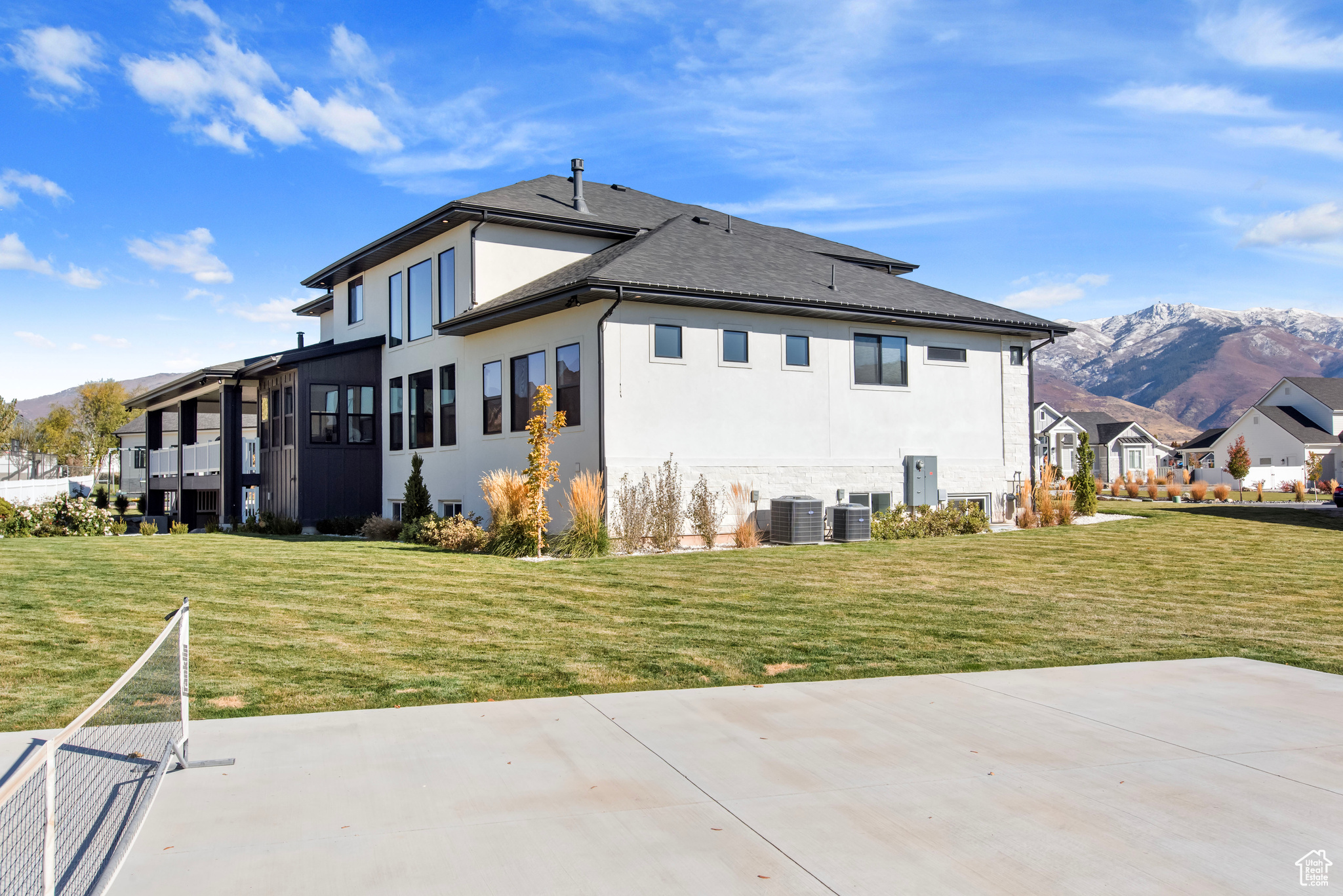 Back of house with a lawn, a patio area, a mountain view, and cooling unit