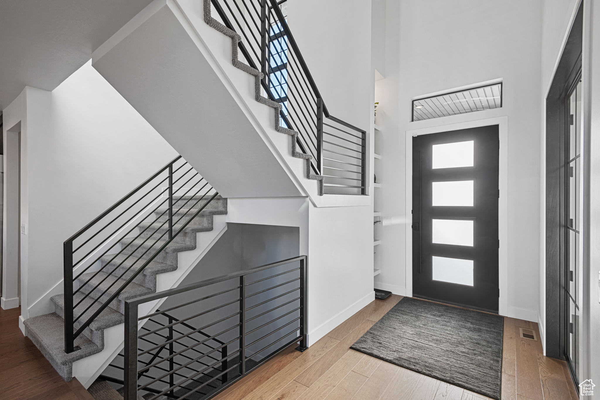 Foyer entrance with wood-type flooring and a high ceiling