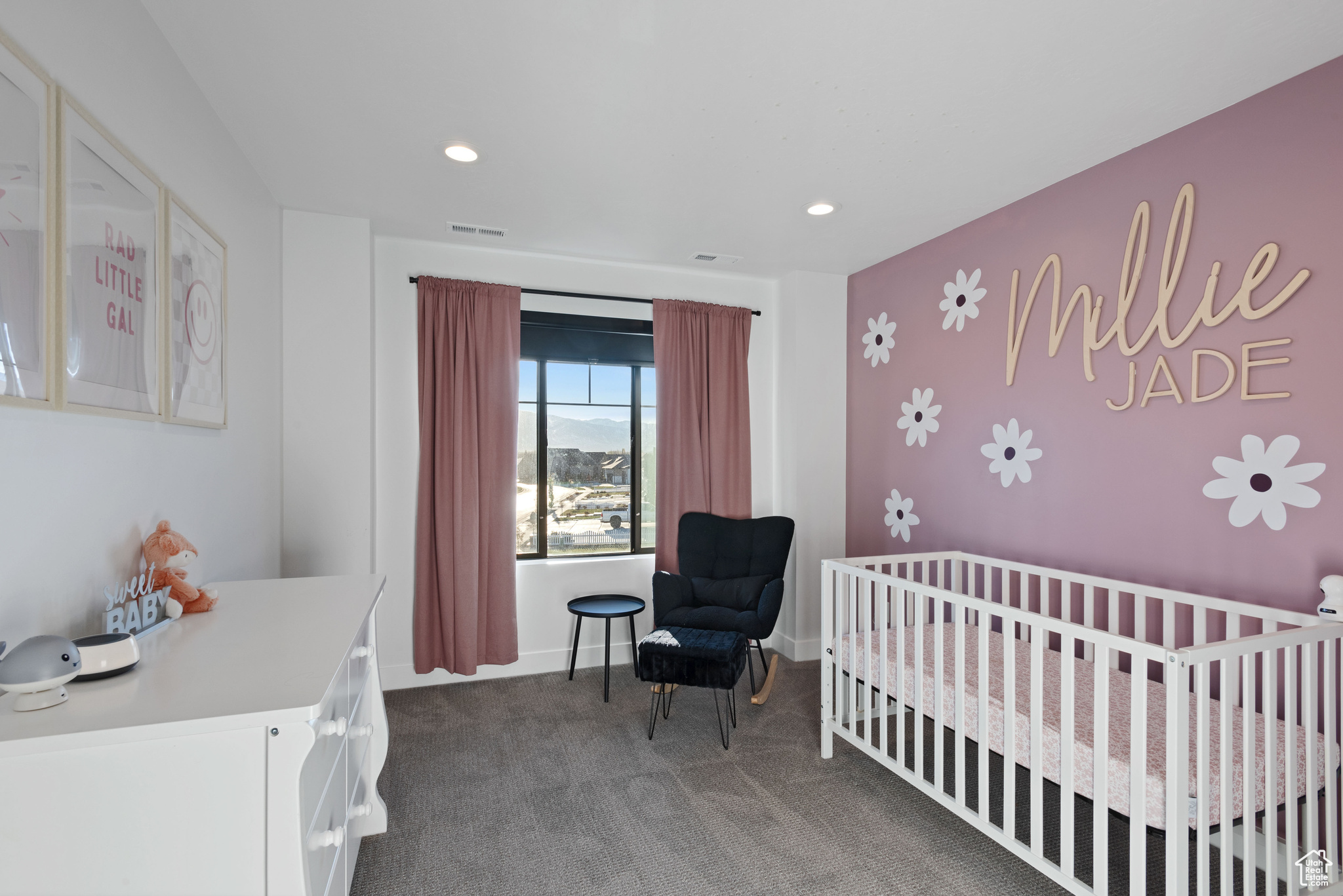 Carpeted bedroom featuring a nursery area