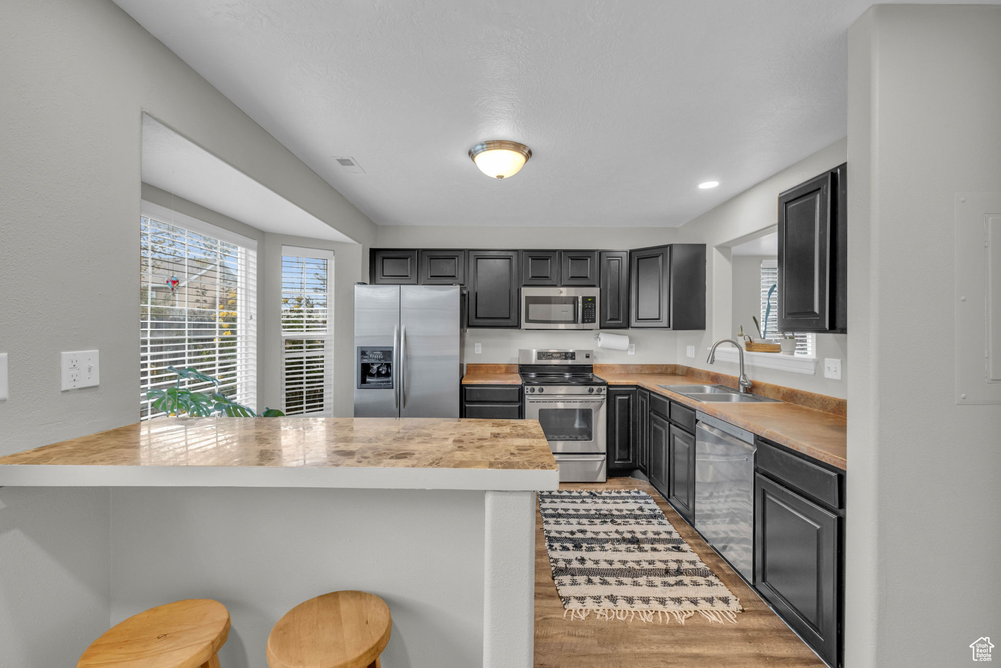 Kitchen with breakfast bar, stainless steel appliances, and LVP flooring