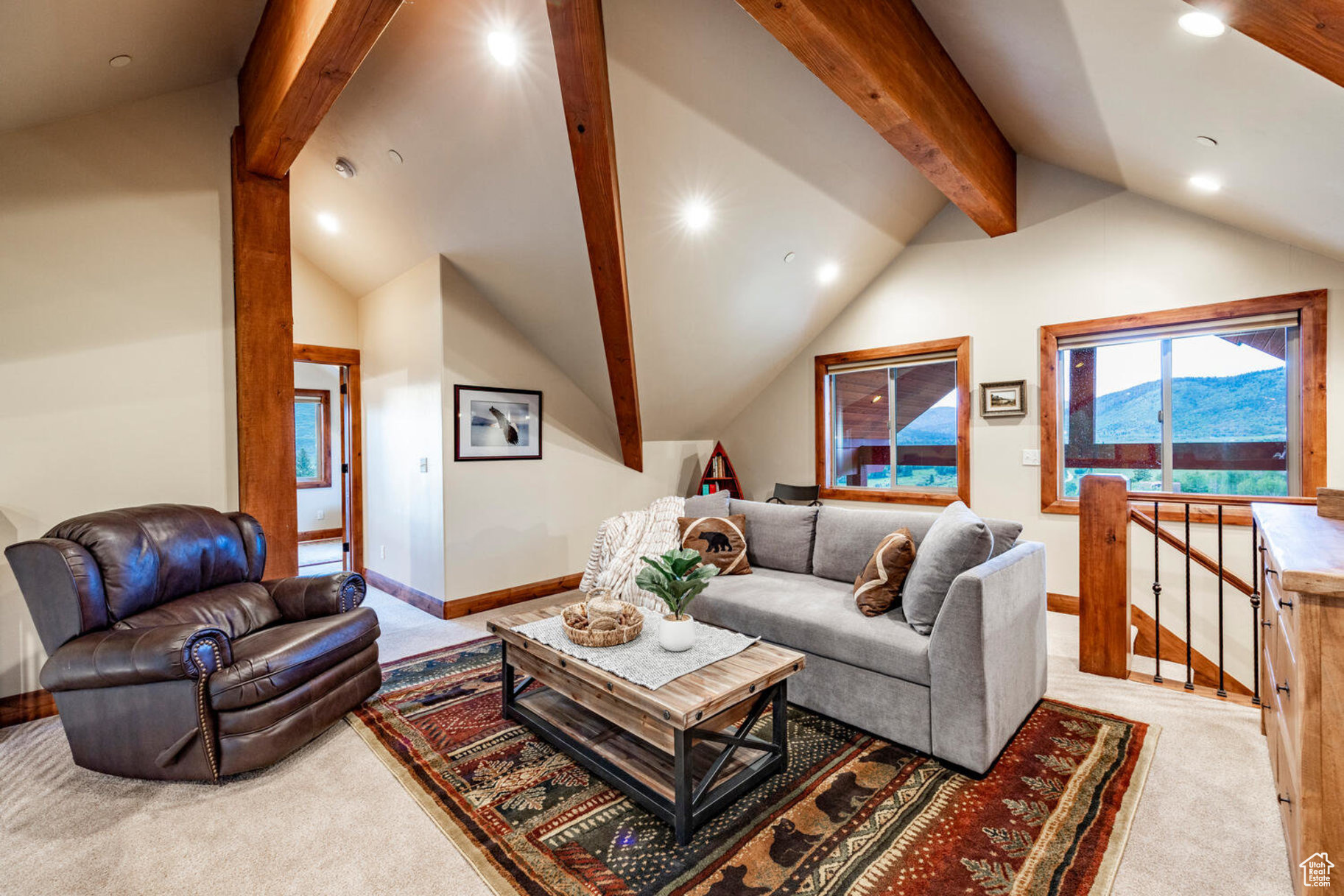 Living room featuring light colored carpet and lofted ceiling with beams