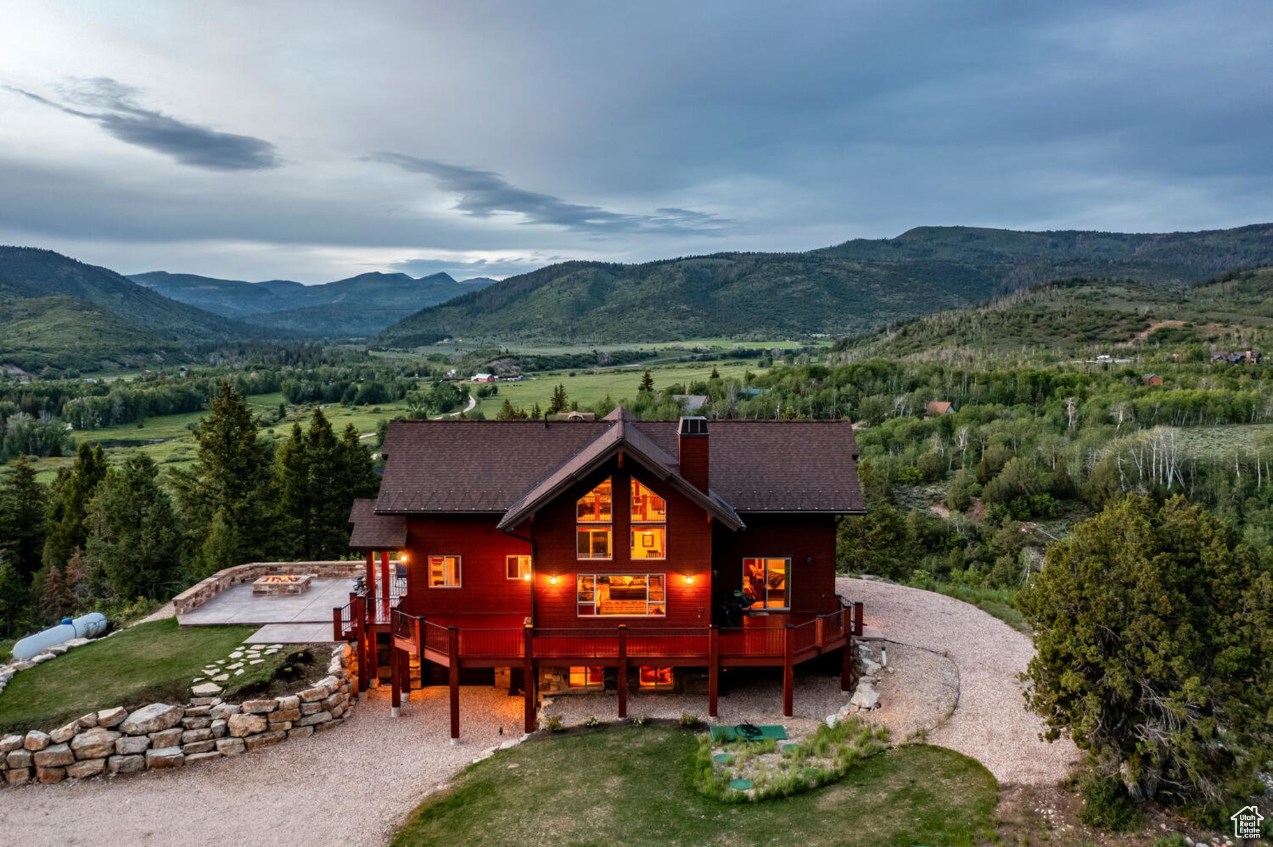 Back of property with a deck with mountain view and a yard