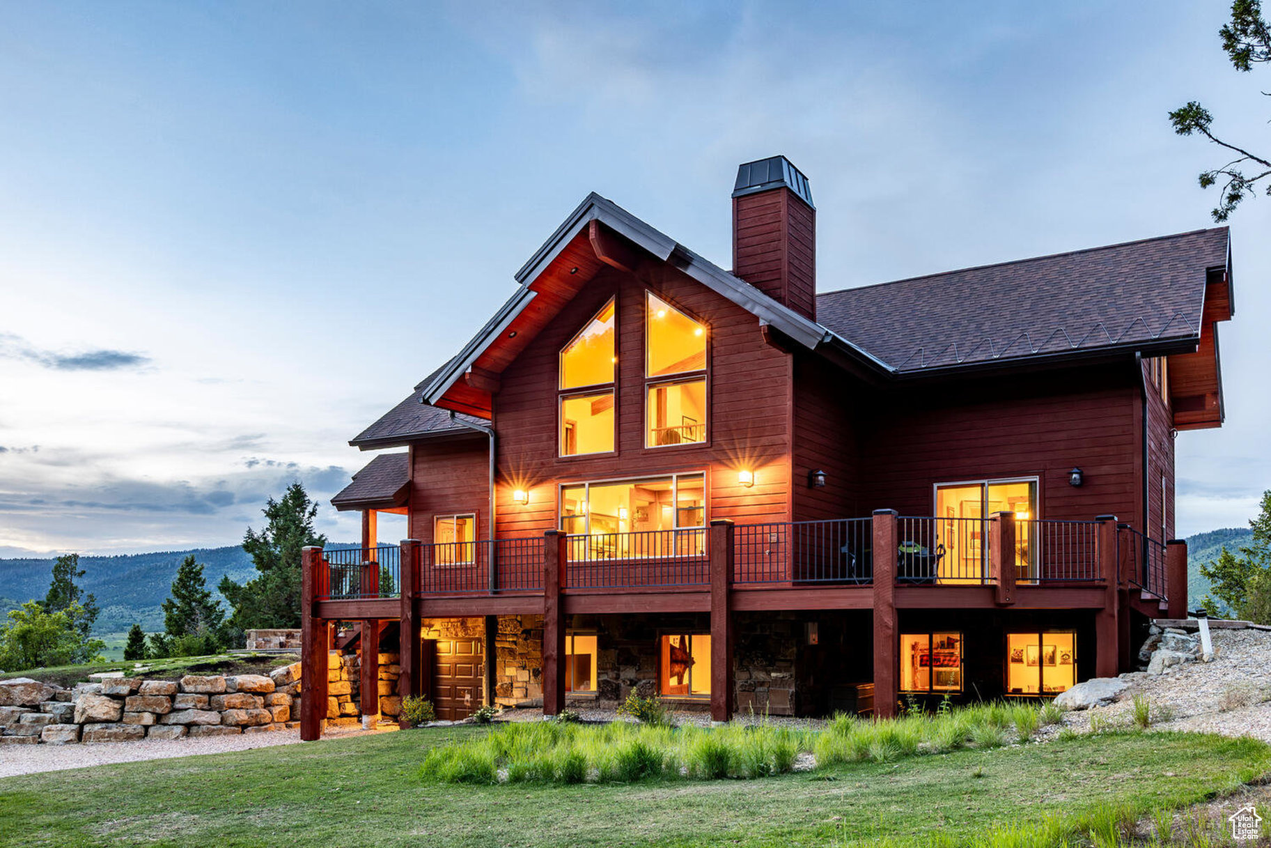 Rear view of house with a deck with mountain view and a yard