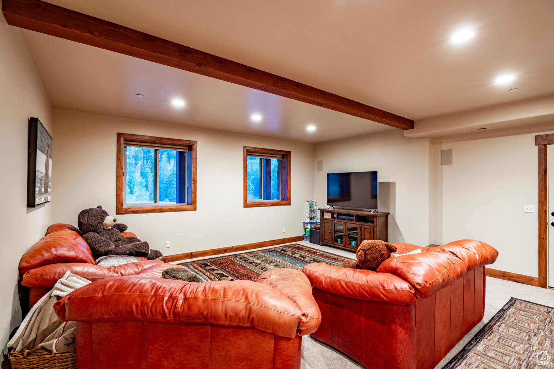 Carpeted living room with beam ceiling