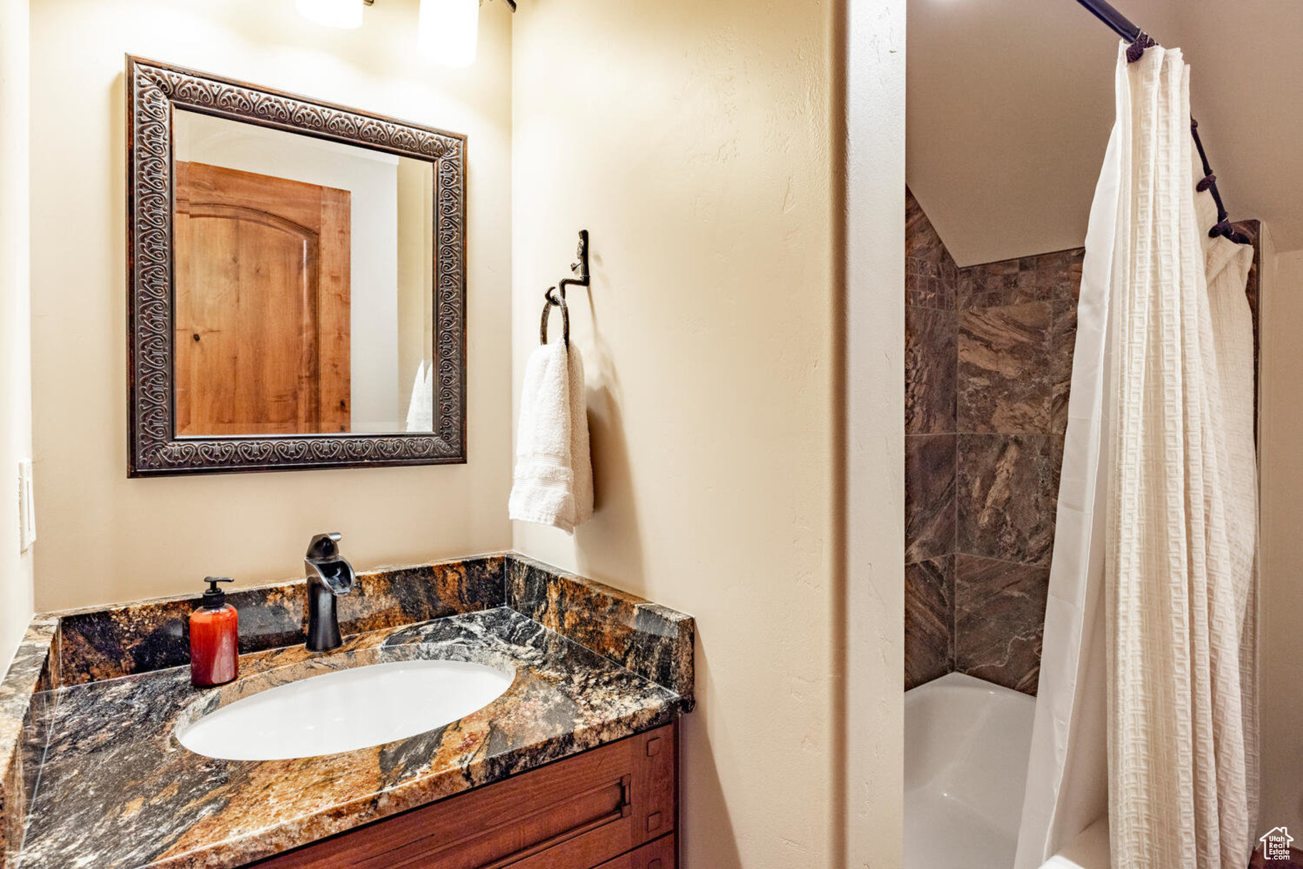 Bathroom with vanity and shower / bathtub combination with curtain