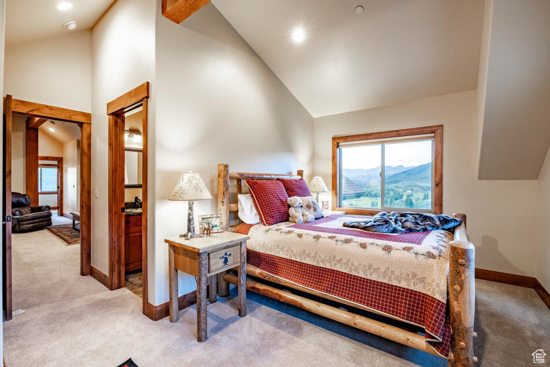 Bedroom with a mountain view, light colored carpet, and high vaulted ceiling