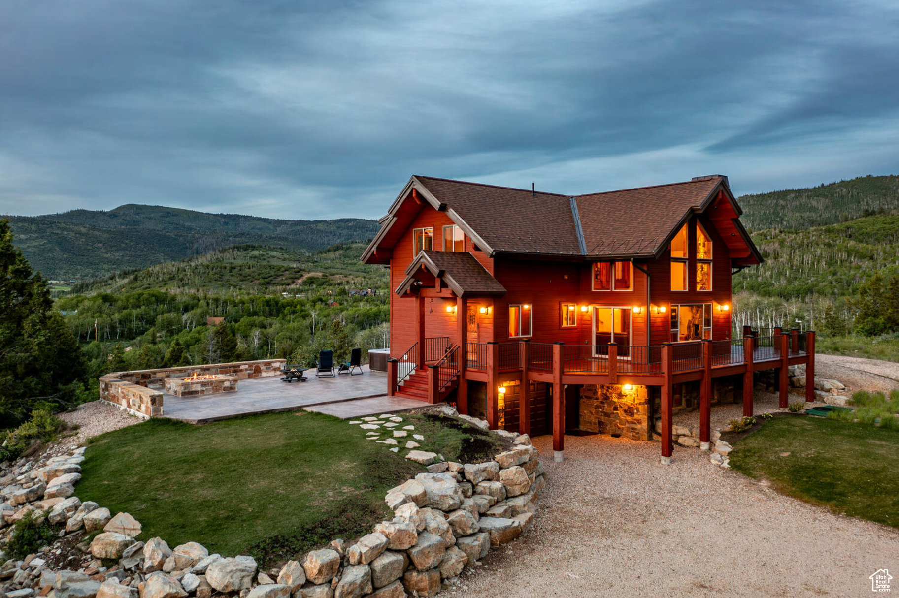 Back of house featuring a lawn, a deck with mountain view, a patio, and an outdoor fire pit