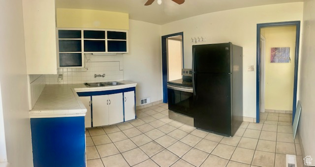 Kitchen featuring black appliances, white cabinets, sink, ceiling fan, and tasteful backsplash