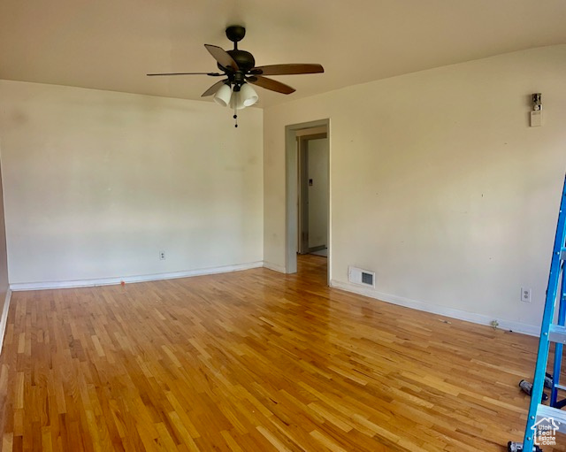 Empty room with light hardwood / wood-style floors and ceiling fan