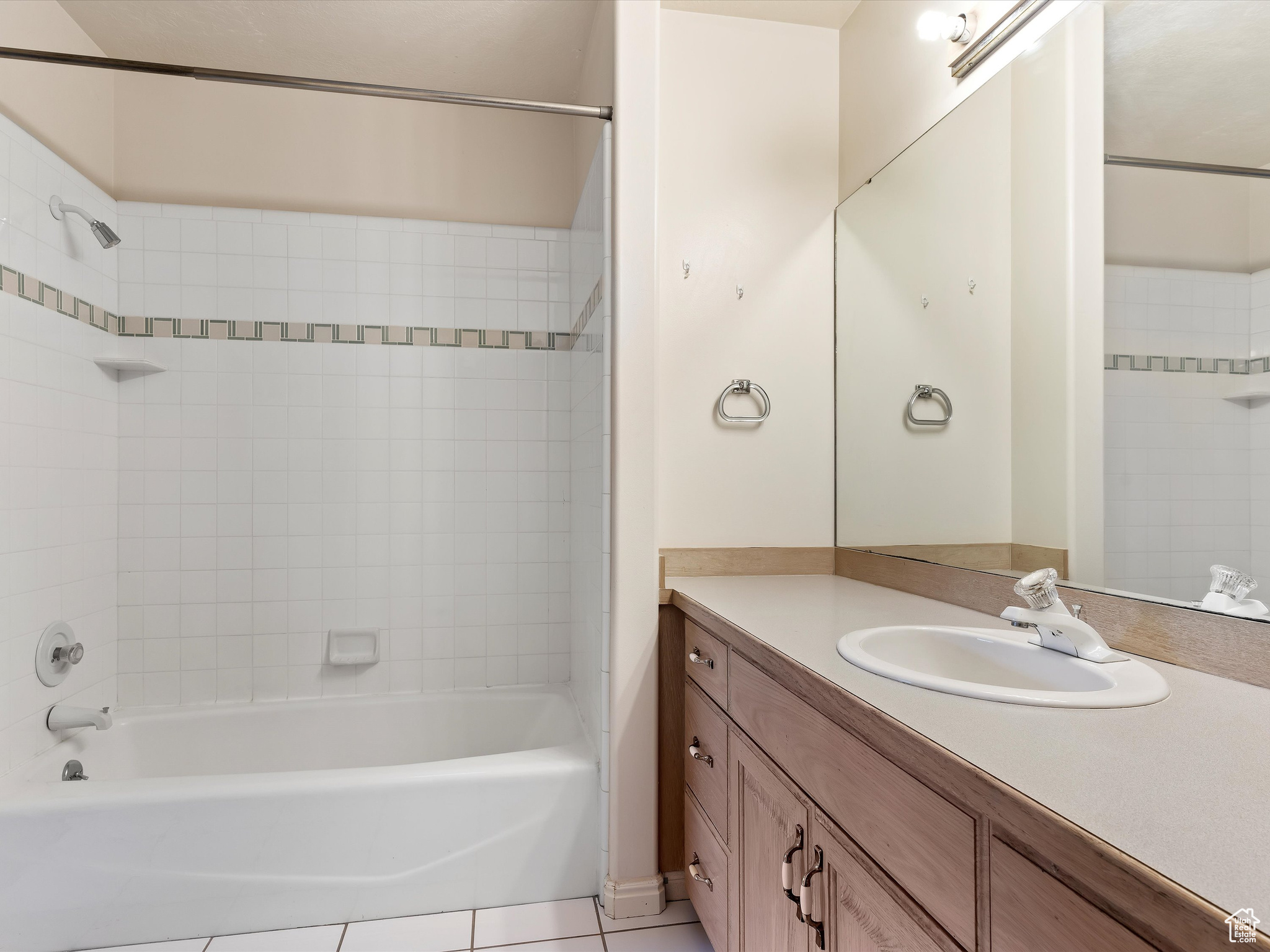 Bathroom with tile patterned flooring, vanity, and tiled shower / bath