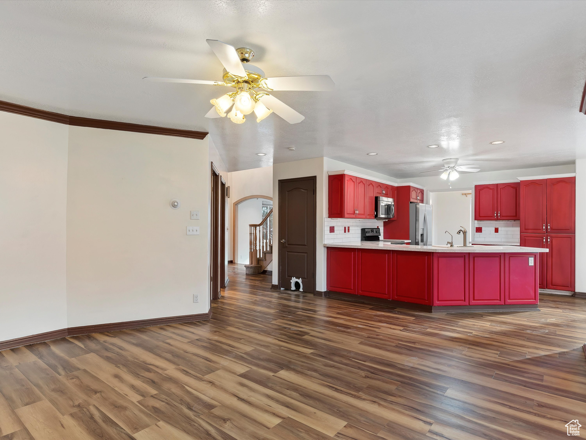 Kitchen featuring backsplash, dark hardwood / wood-style flooring, ornamental molding, and stainless steel appliances