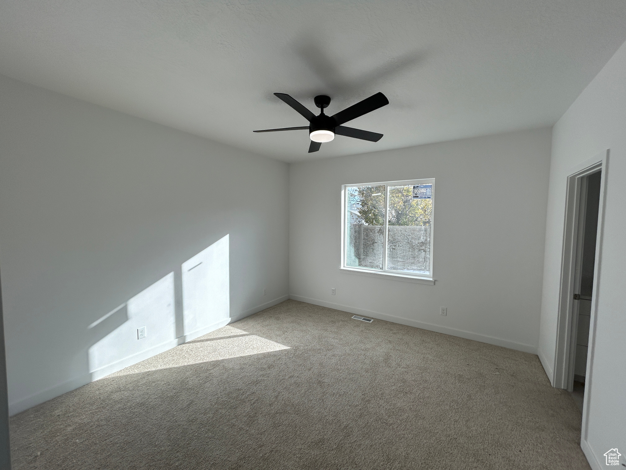 Carpeted empty room with ceiling fan