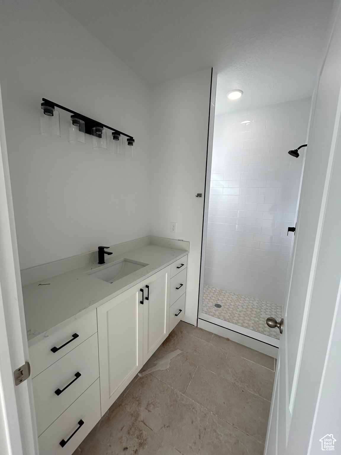 Bathroom featuring a tile shower and vanity