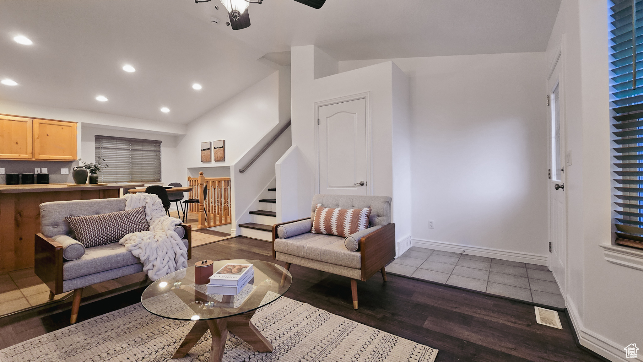 Living room with dark hardwood / wood-style flooring, vaulted ceiling, and ceiling fan