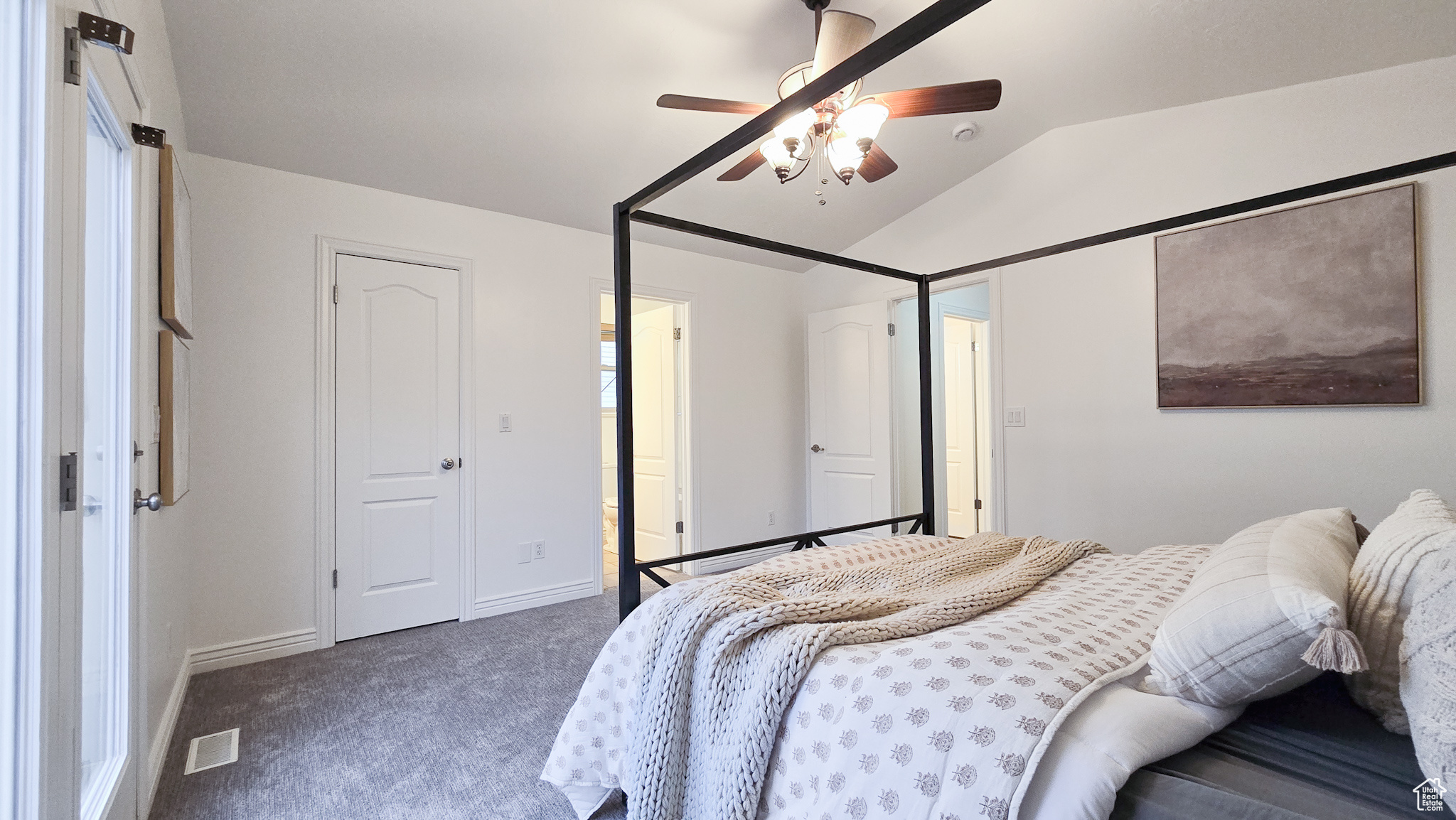 Bedroom with dark colored carpet, ceiling fan, and lofted ceiling