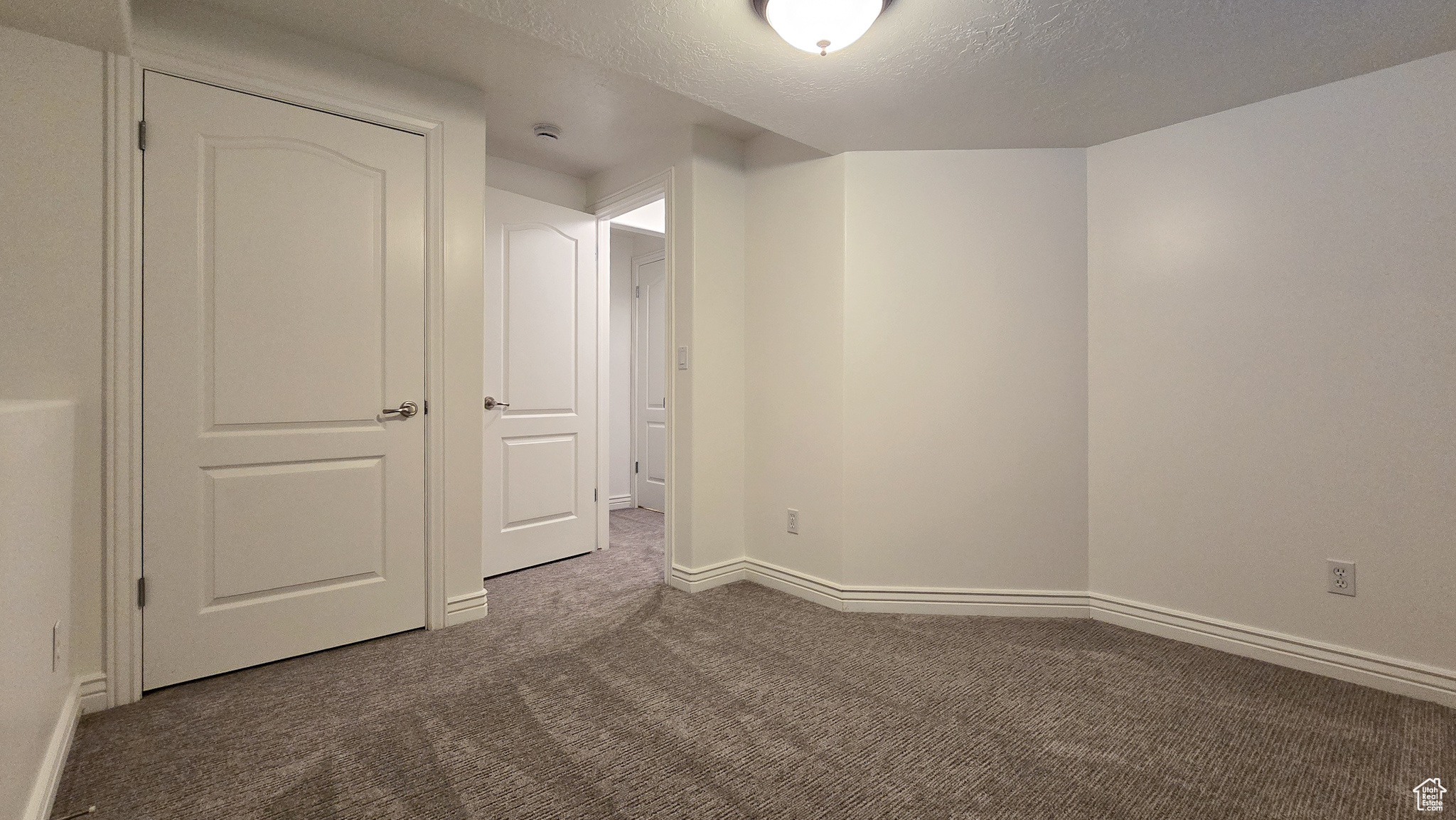 Carpeted empty room with a textured ceiling