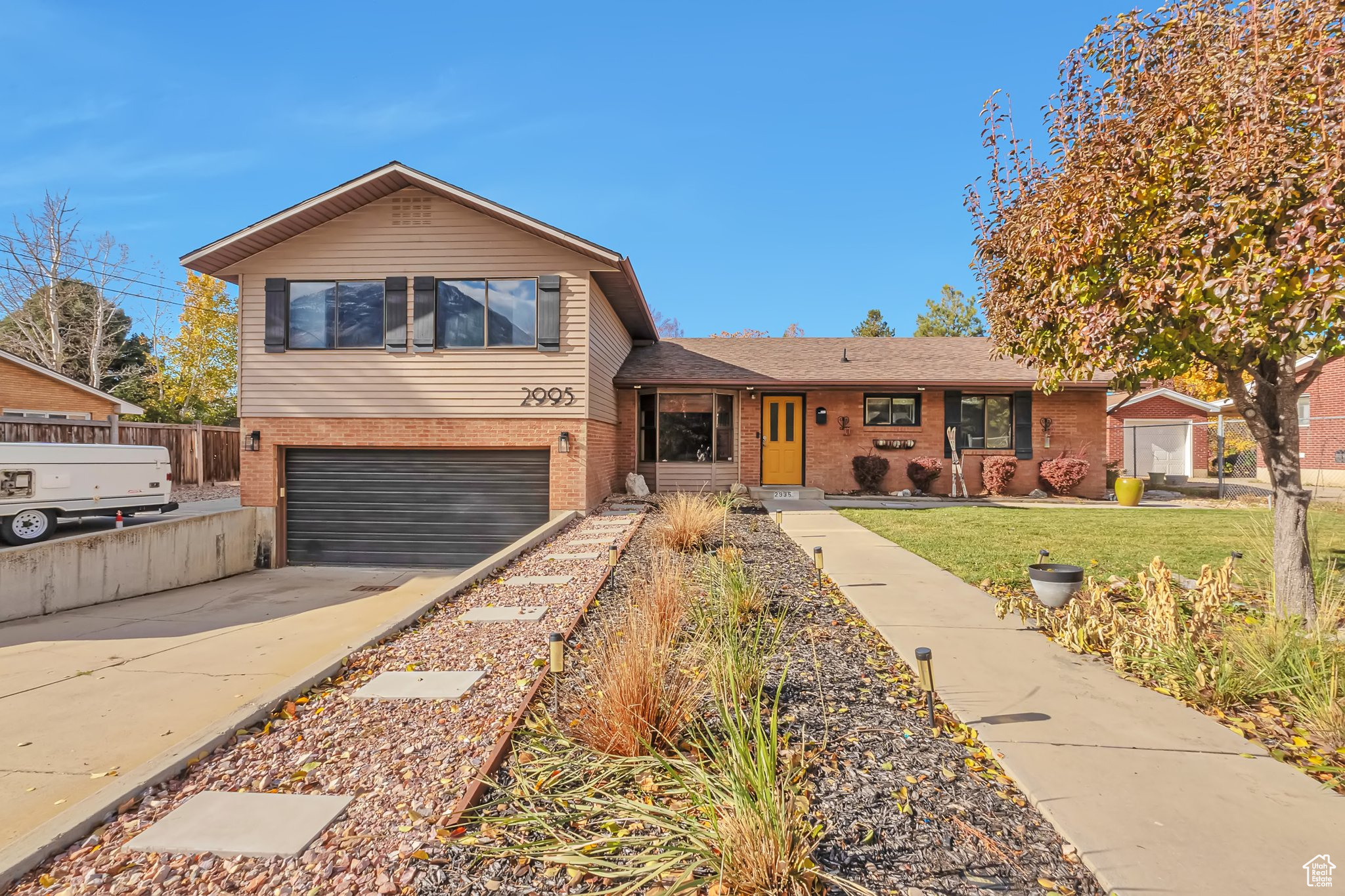 Split level home with a garage and a front lawn