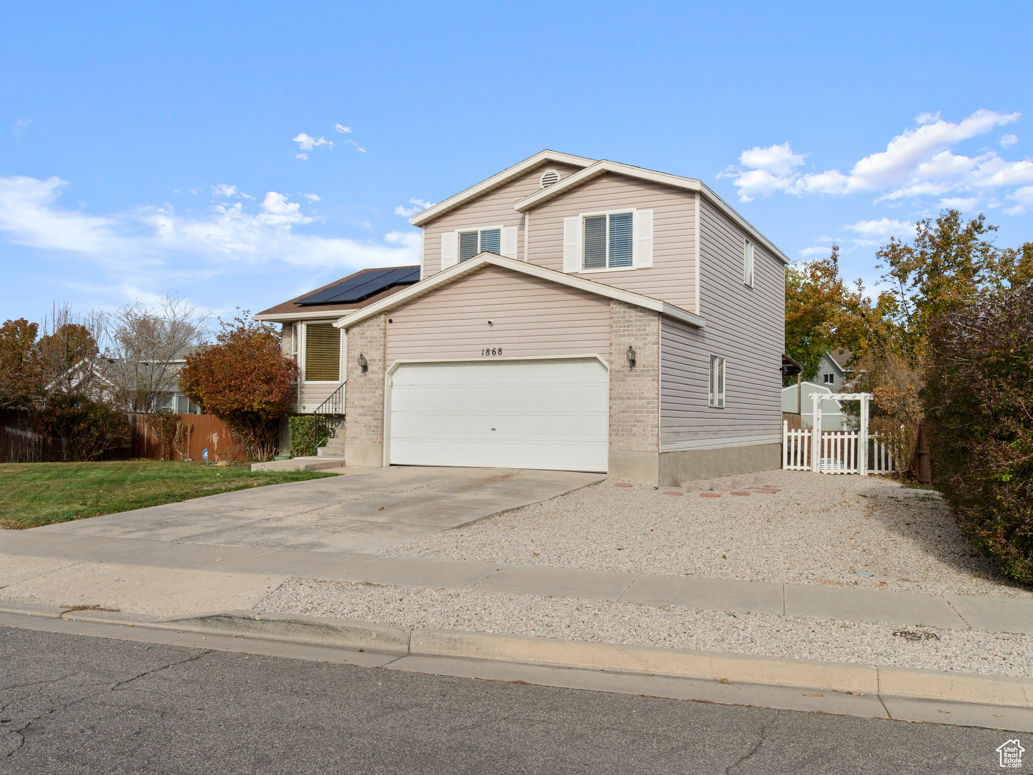 Front of property featuring solar panels and a garage