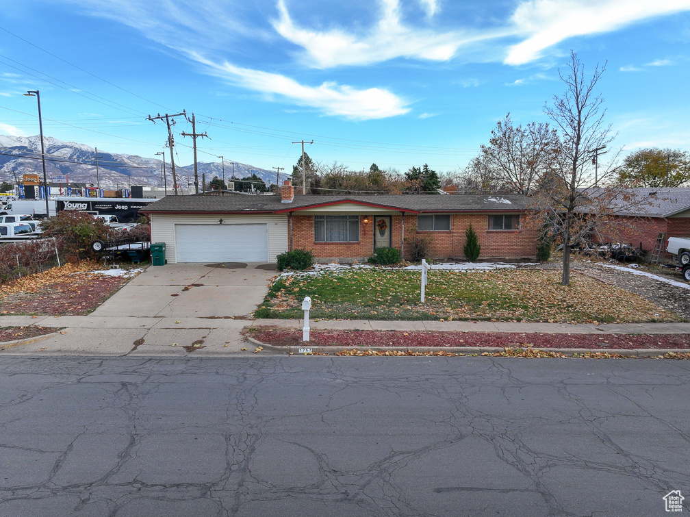 Single story home featuring a mountain view, a garage, and a front yard