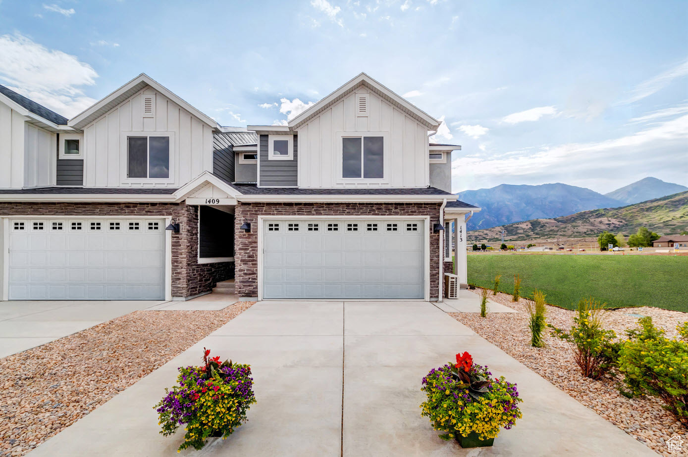 View of front of house with a mountain view and a garage