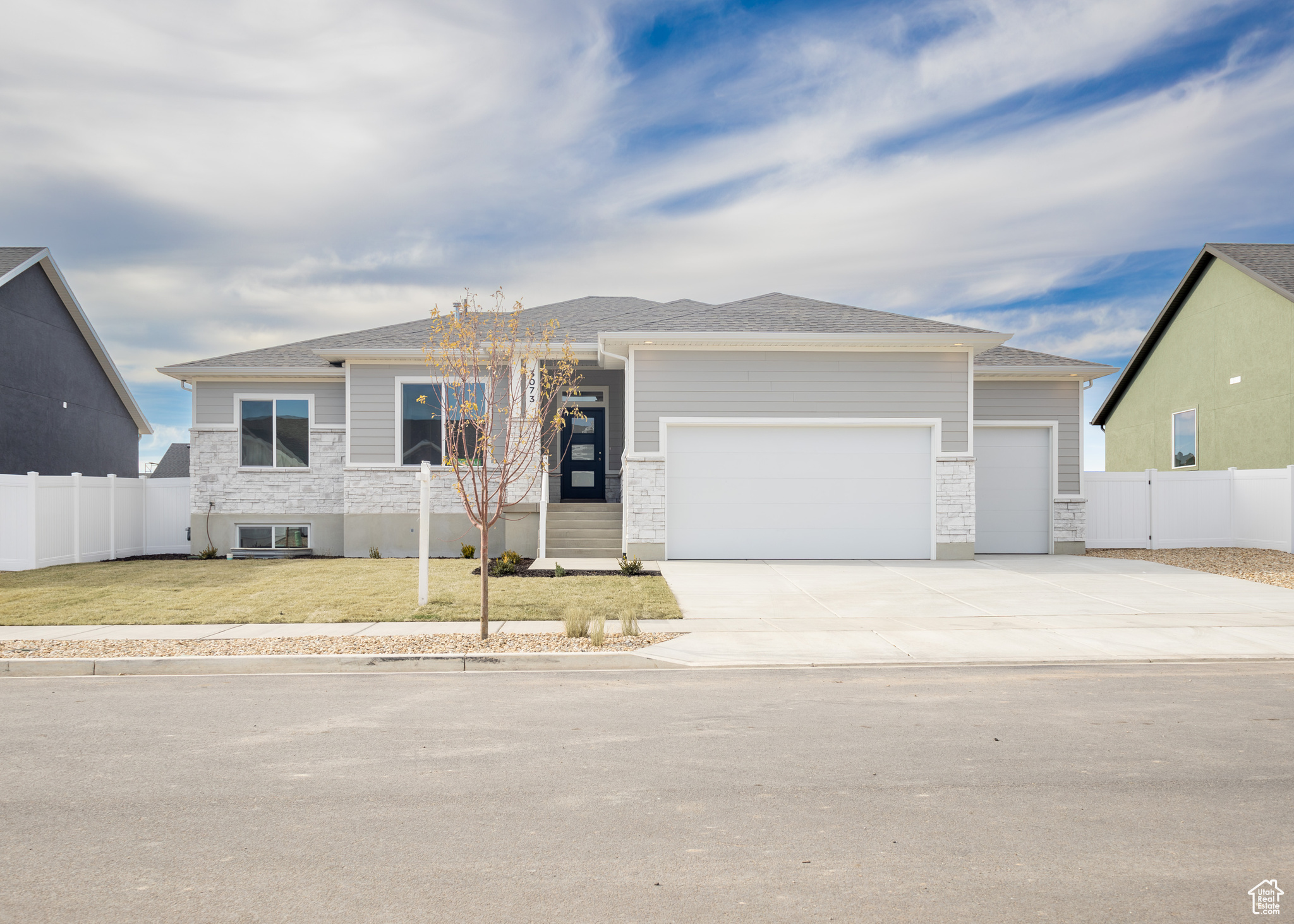 View of front facade featuring a garage and a front lawn