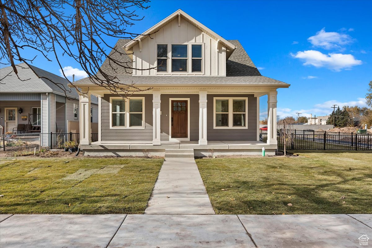 Bungalow featuring a front yard and a porch