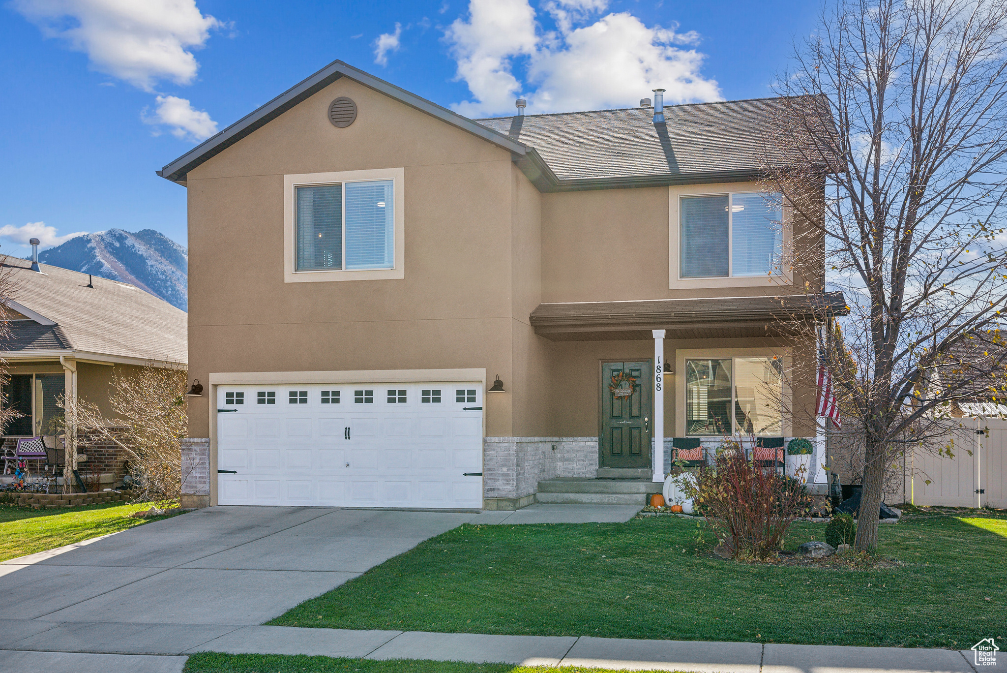 View of front of house with a front yard, a mountain view, and a garage