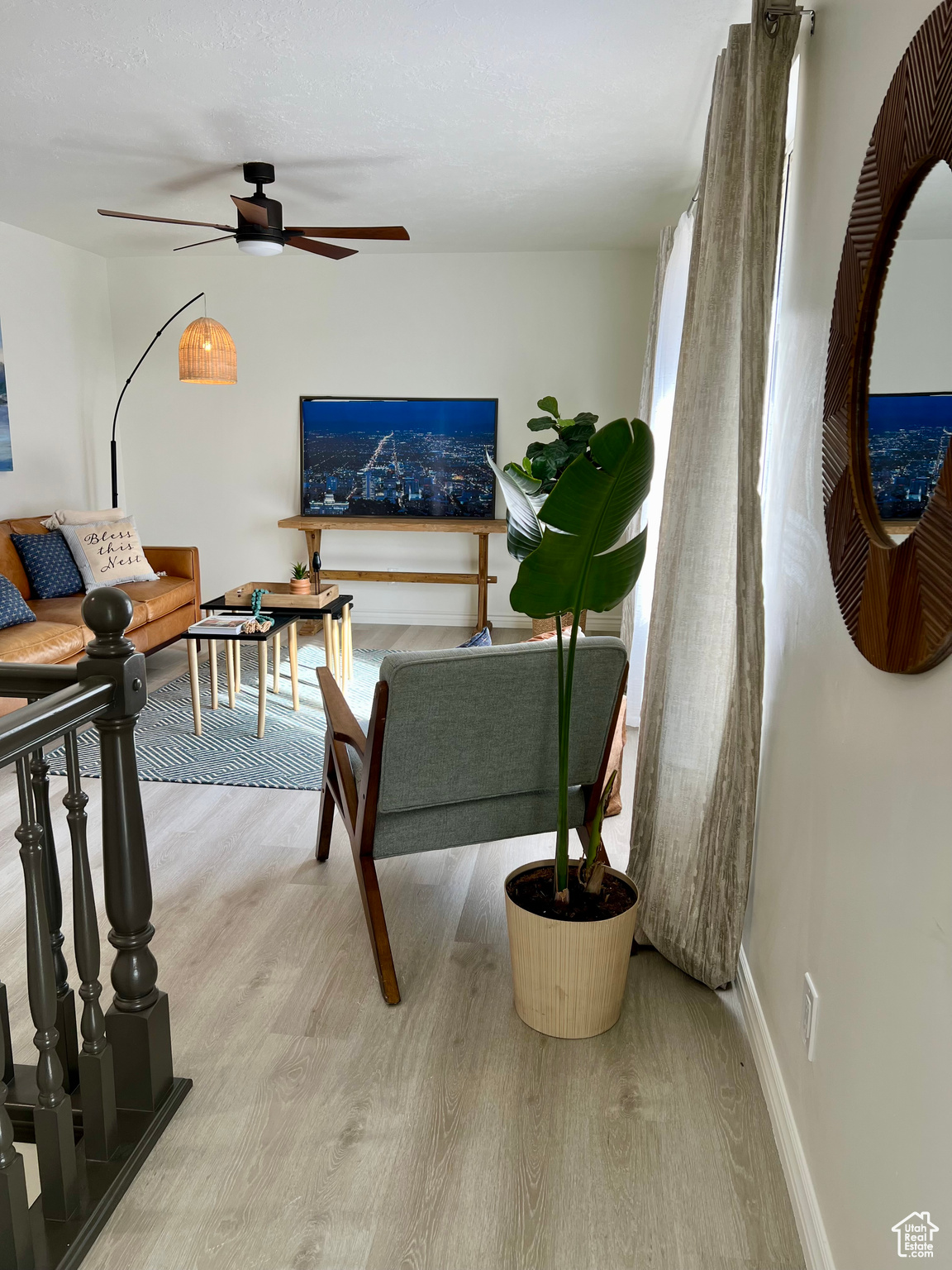 Living room with light hardwood / wood-style flooring and ceiling fan