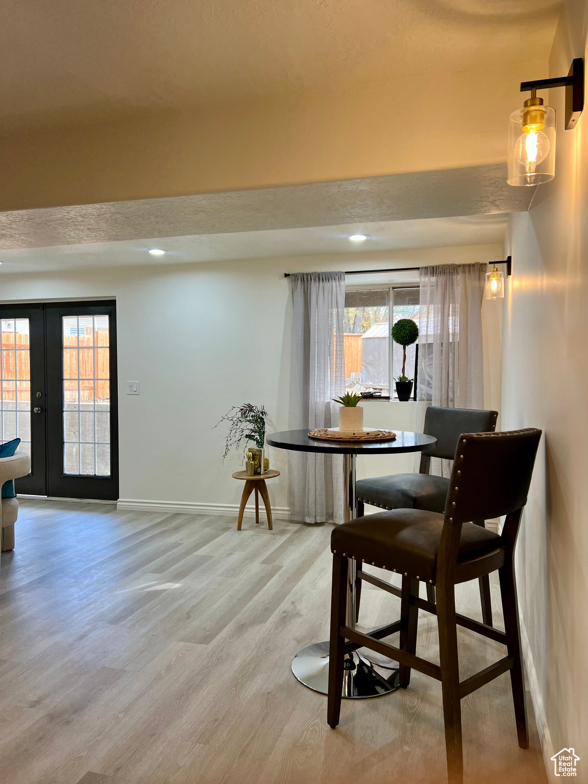 Dining space with hardwood / wood-style floors, french doors, a textured ceiling, and plenty of natural light