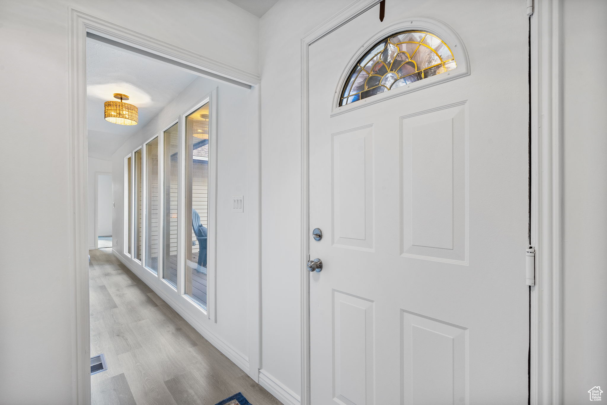 Entrance foyer with light hardwood / wood-style flooring and a healthy amount of sunlight