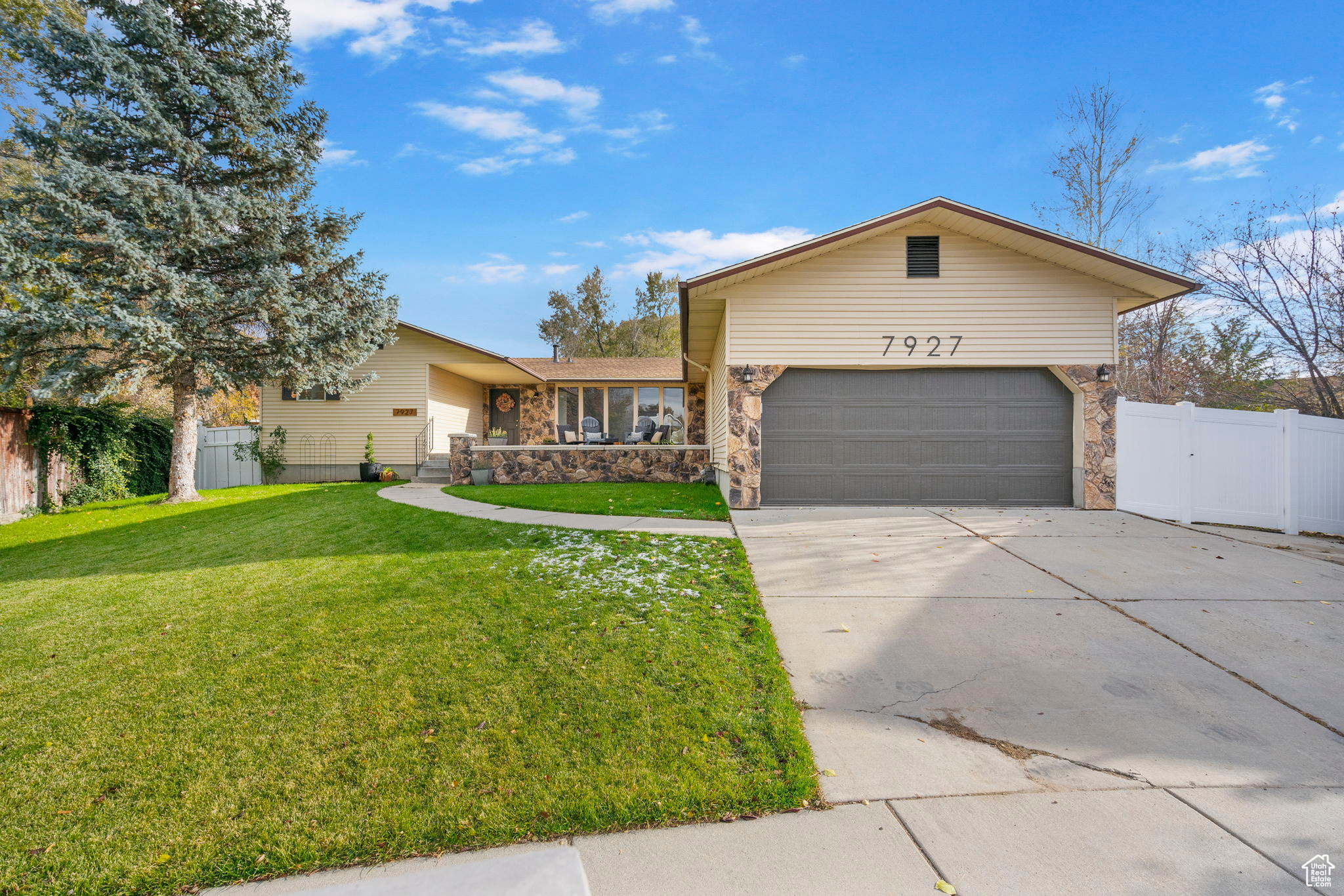 Ranch-style house featuring a garage and a front yard