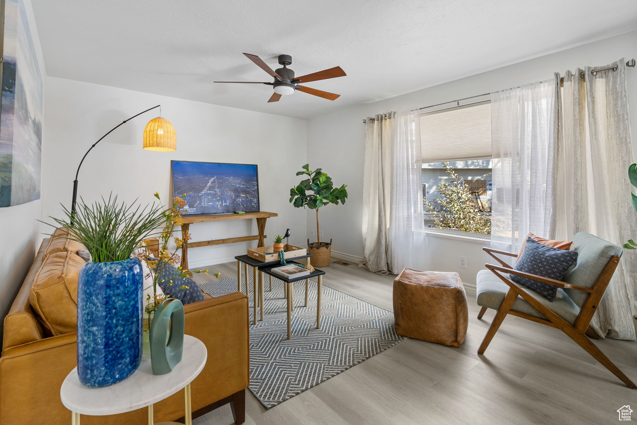 Living room featuring ceiling fan and light wood-type flooring