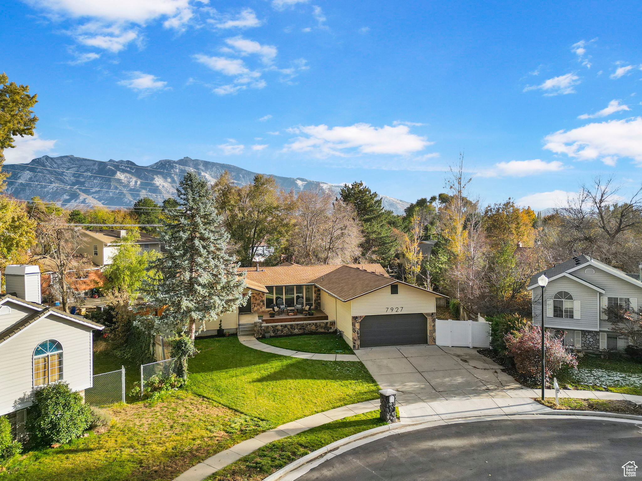 Single story home featuring a mountain view, a garage, and a front yard