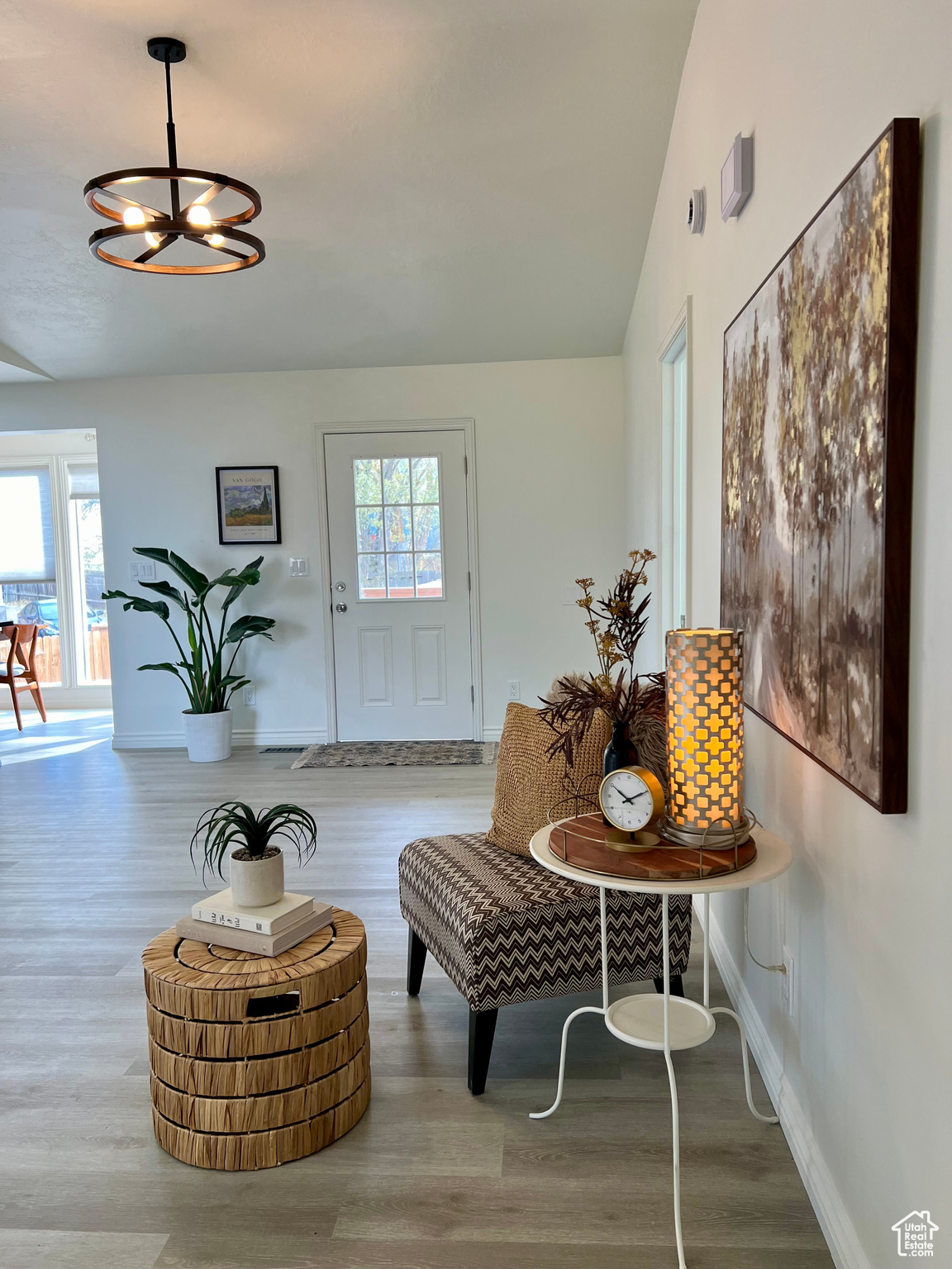 Living area with a notable chandelier, lofted ceiling, and hardwood / wood-style flooring