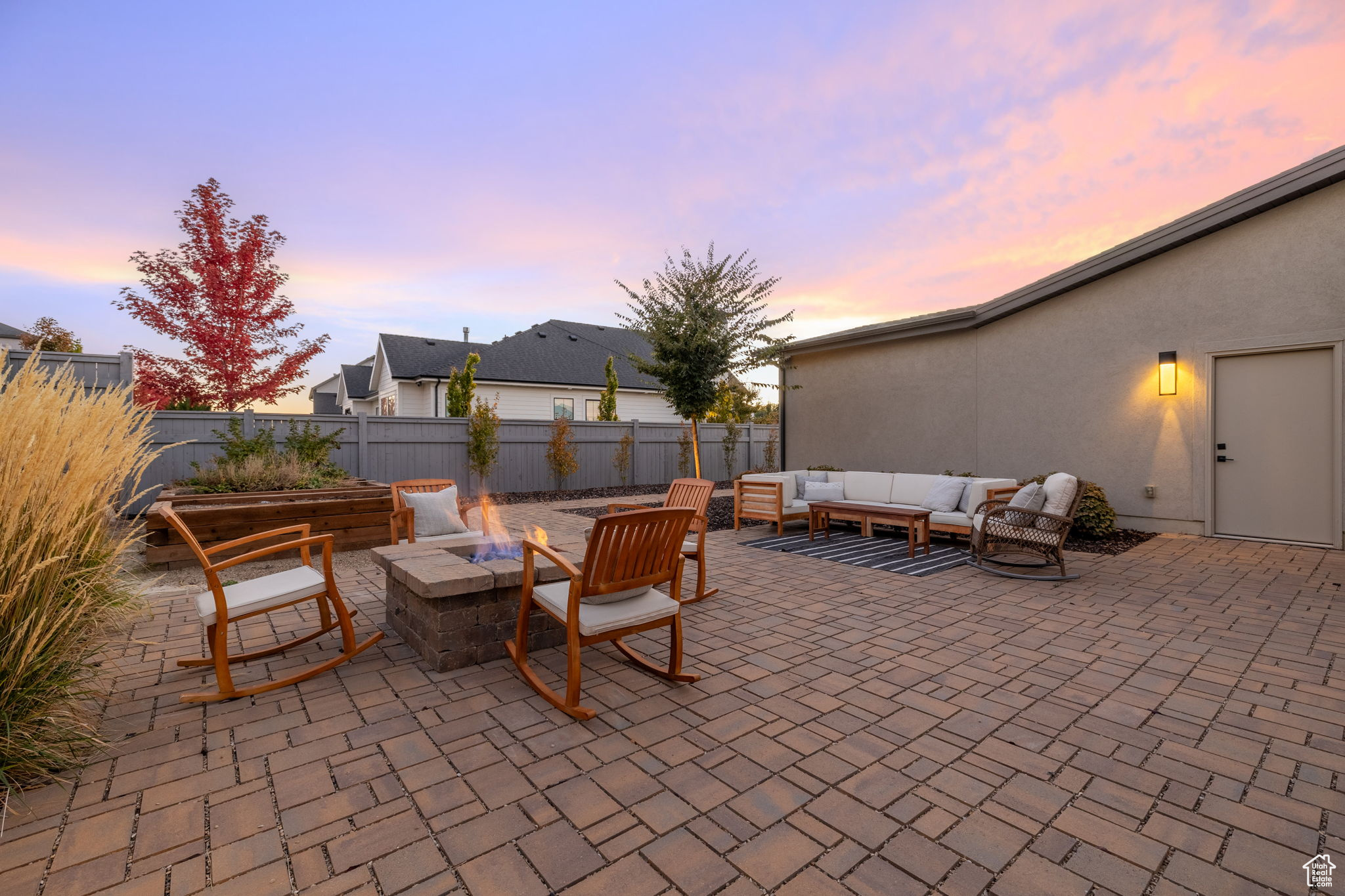 Patio terrace at dusk with an outdoor living space with a fire pit