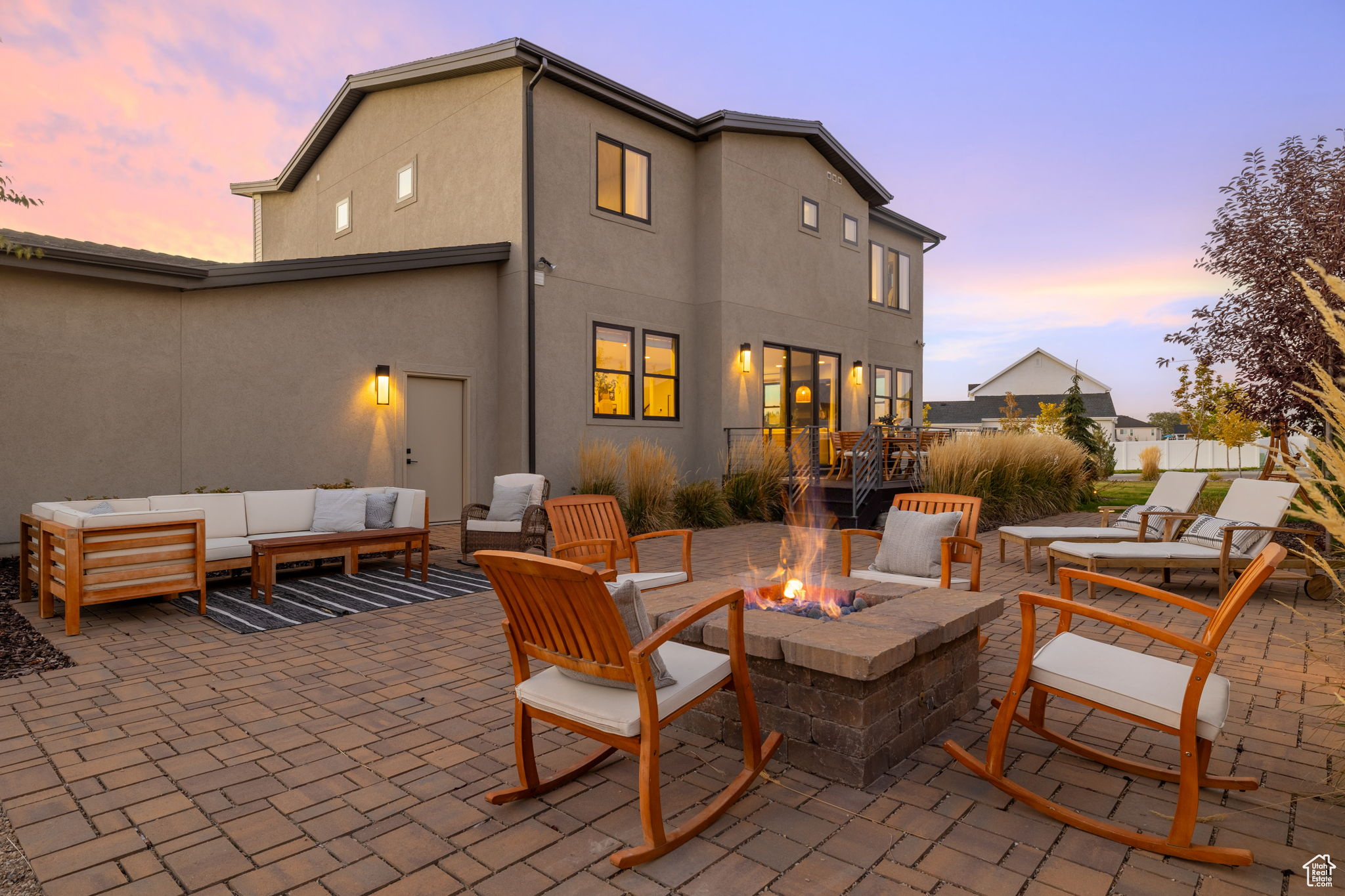 Patio terrace at dusk with an outdoor living space with a fire pit