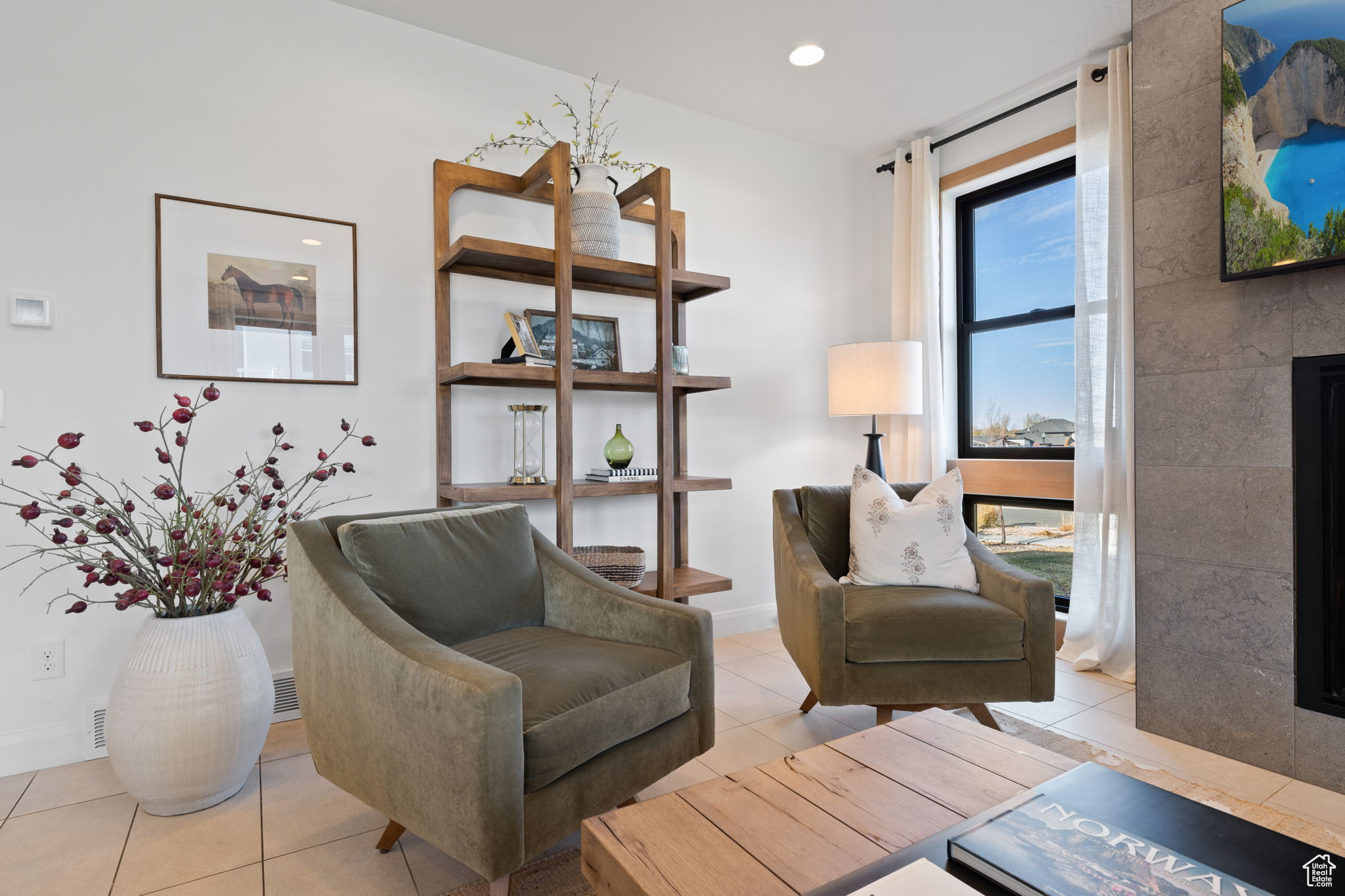 Sitting room with light tile patterned flooring and a tile fireplace