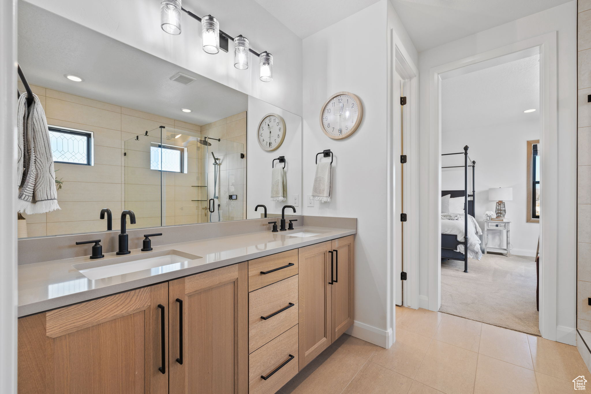 Bathroom featuring tile patterned flooring, vanity, and walk in shower