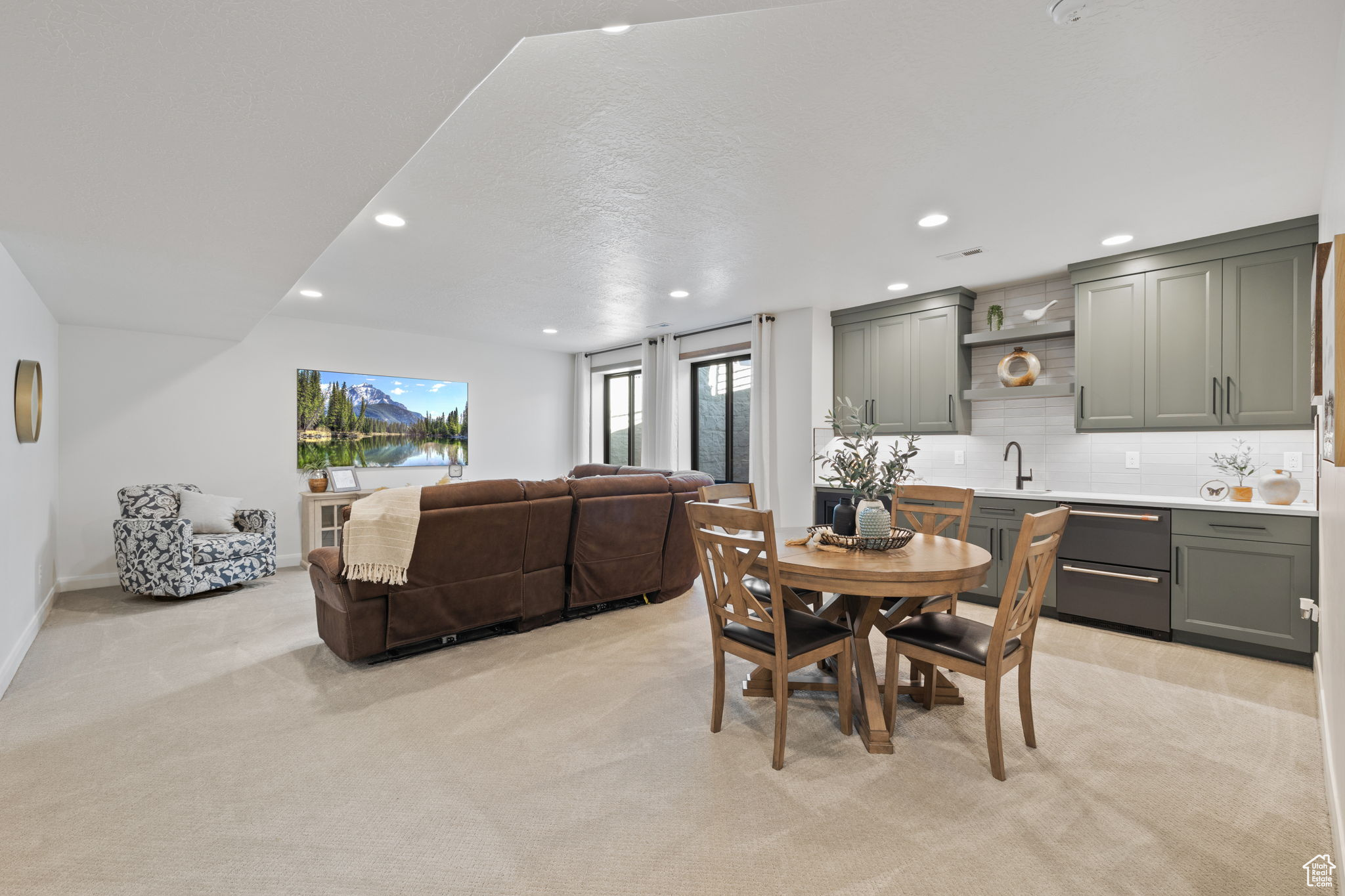 Carpeted dining room with sink and a textured ceiling