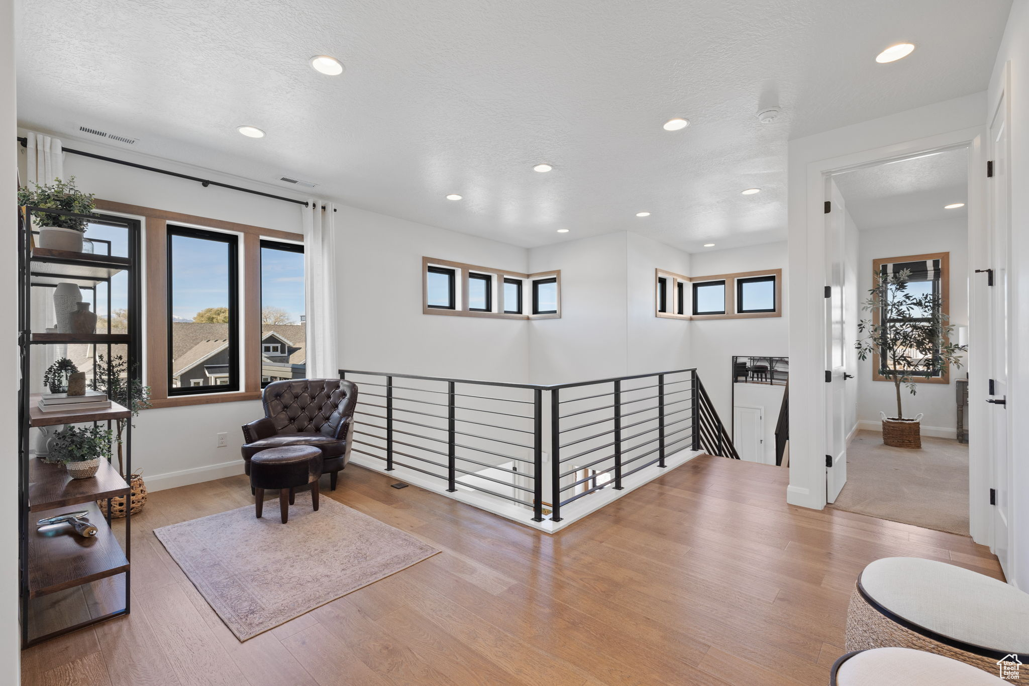 Living area with light wood-type flooring and a textured ceiling