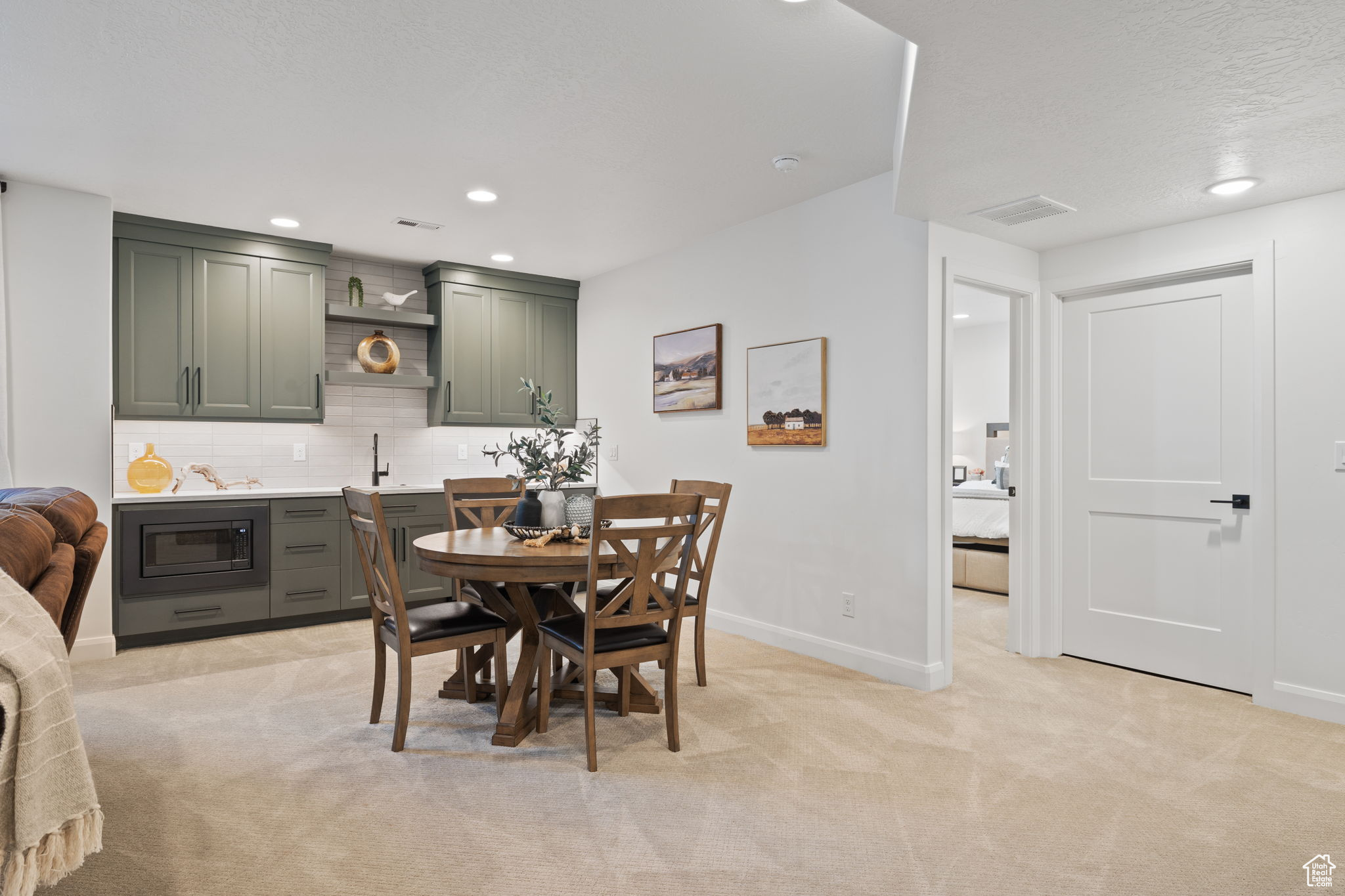 Carpeted dining room featuring sink and a textured ceiling