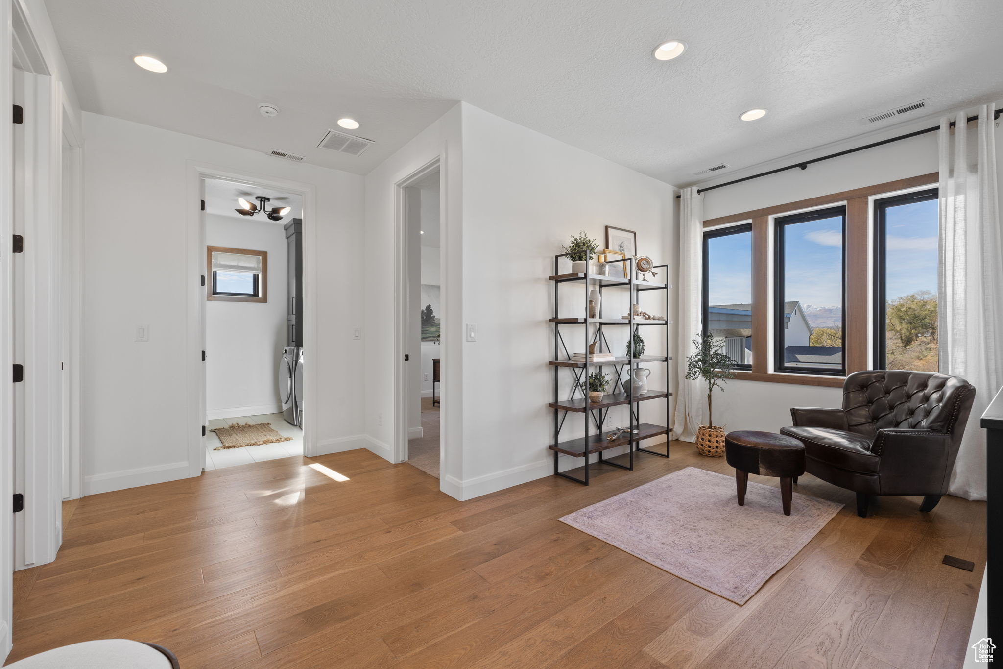 Living area with light hardwood / wood-style floors and a textured ceiling