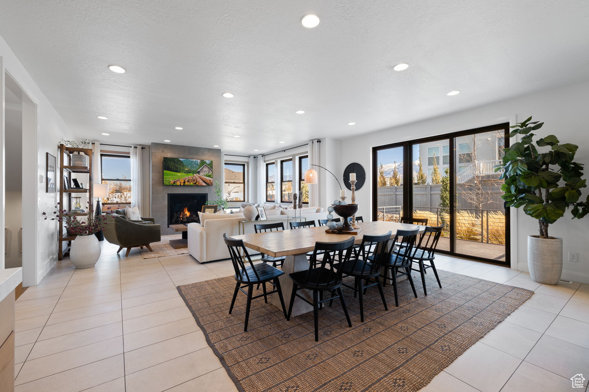 Tiled dining room featuring plenty of natural light, a large fireplace, and a textured ceiling