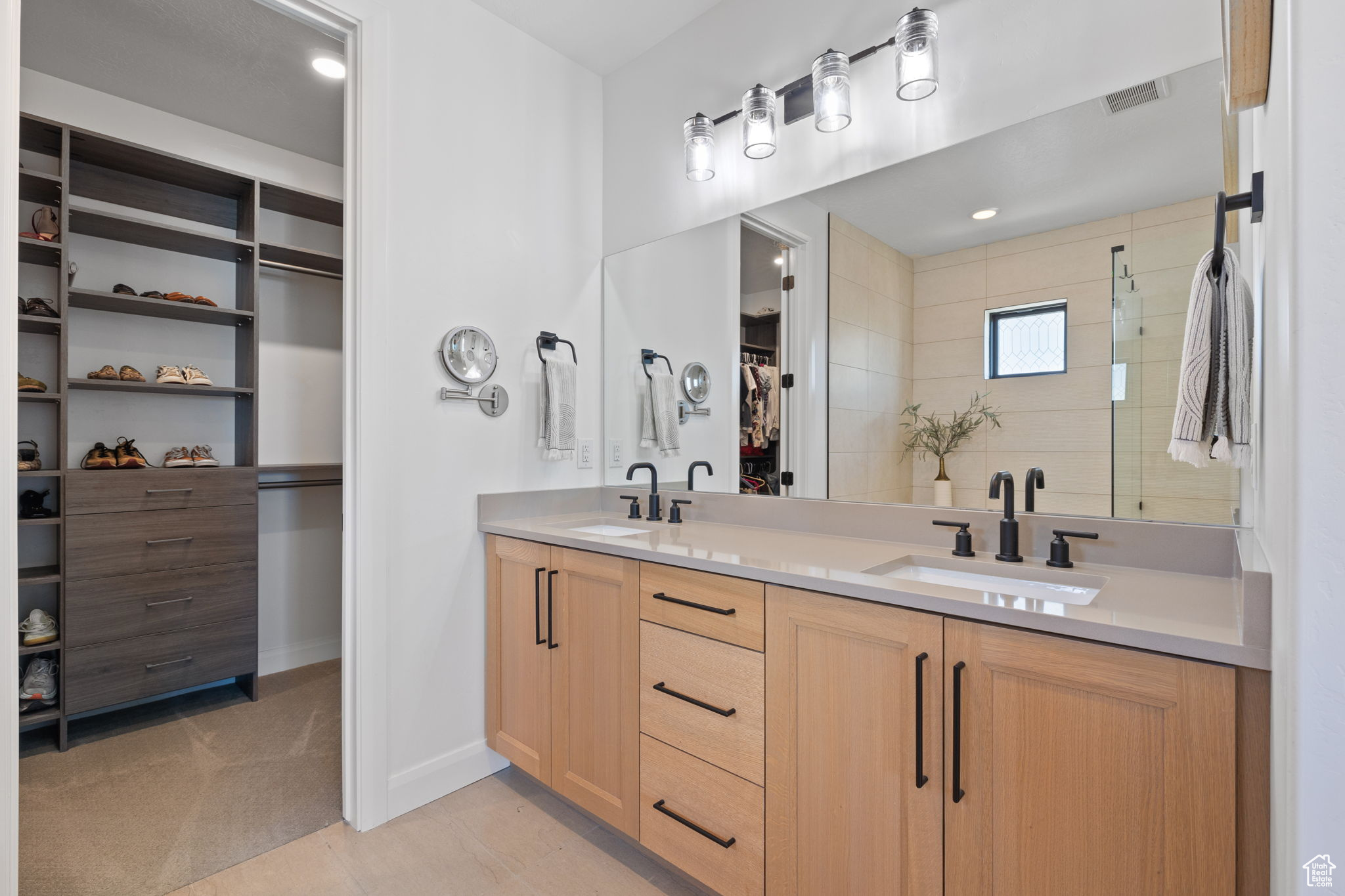 Bathroom with tile patterned flooring, vanity, and walk in shower