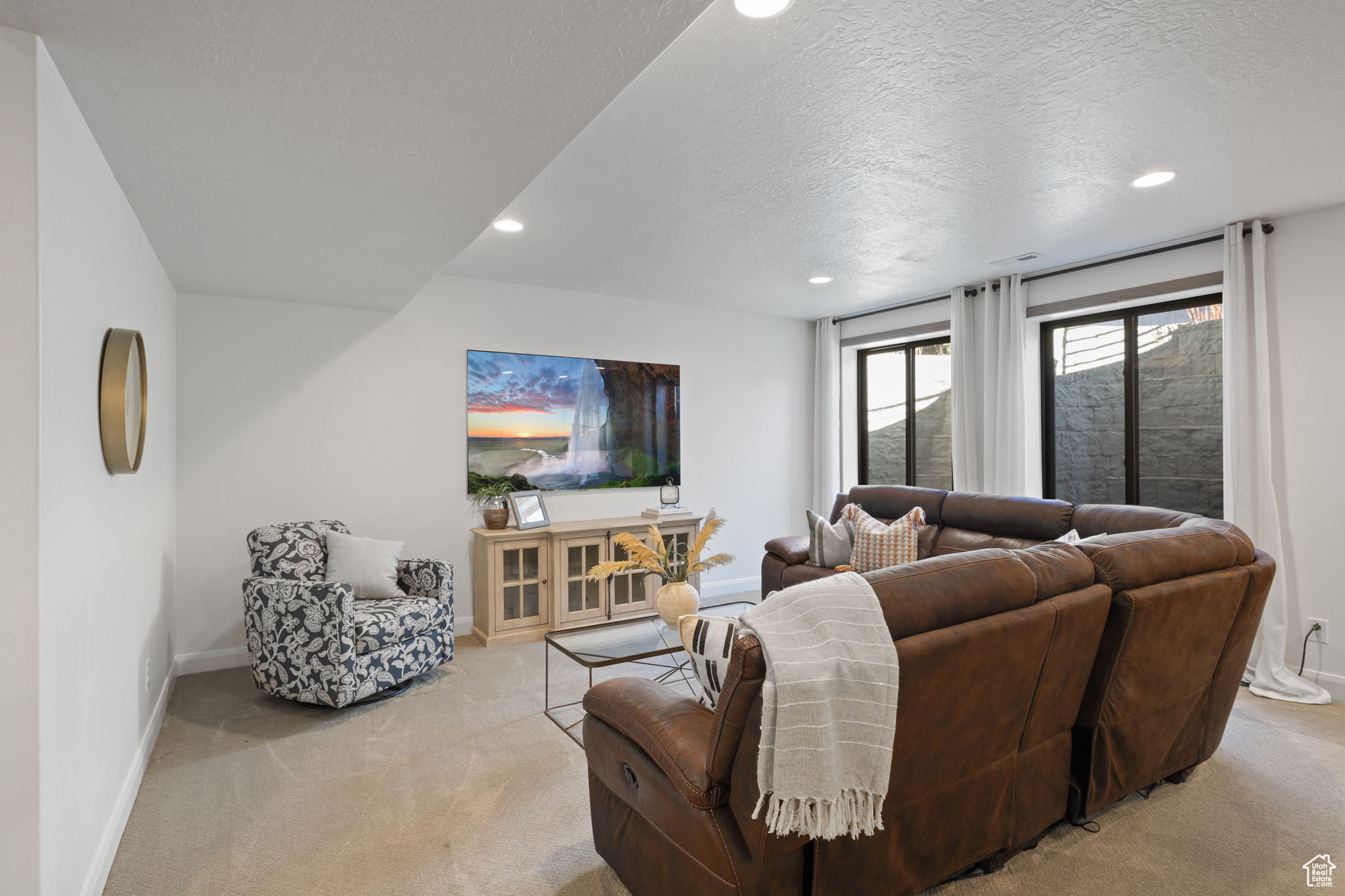 Carpeted living room featuring a textured ceiling