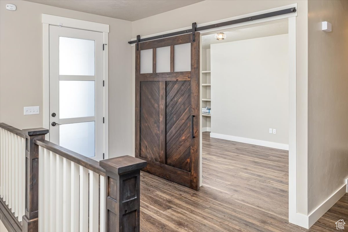 Interior space with a barn door and dark wood-type flooring