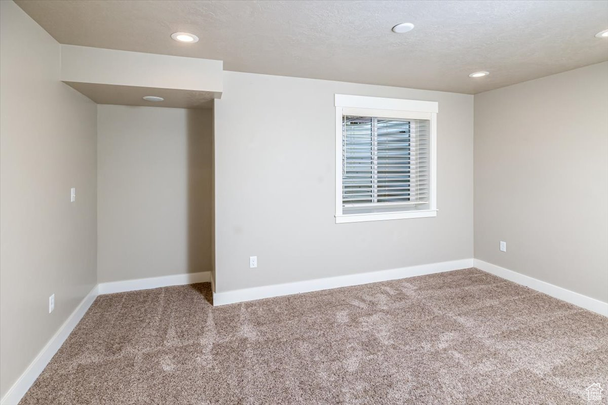 Carpeted empty room featuring a textured ceiling